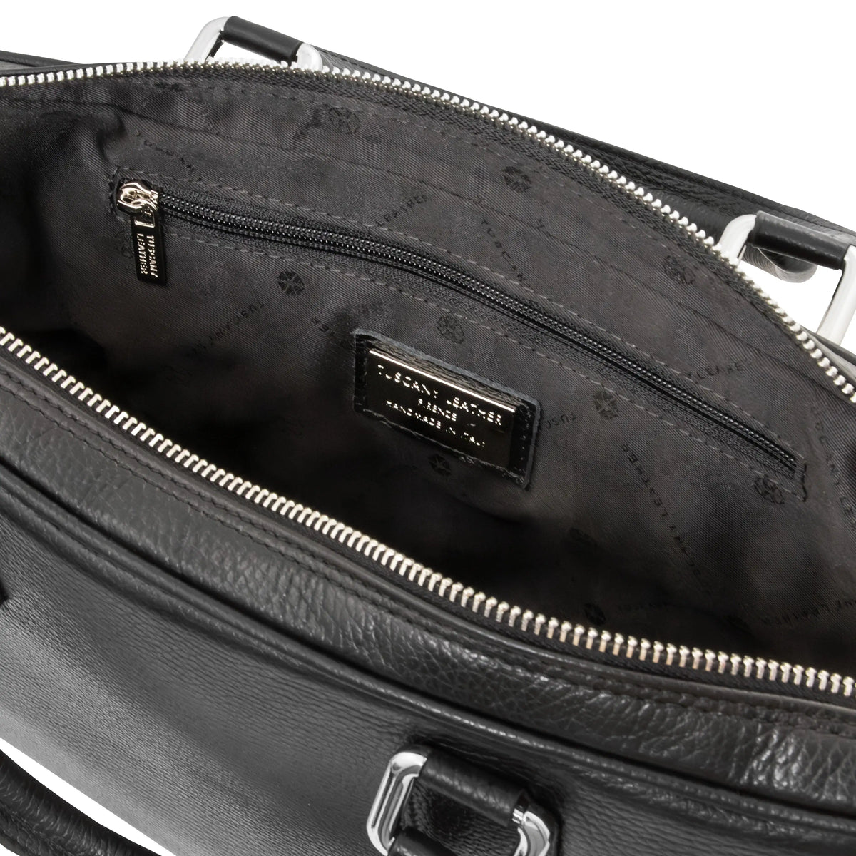 Close-up of a black leather bag with a zipper, showing the black interior and zip pocket