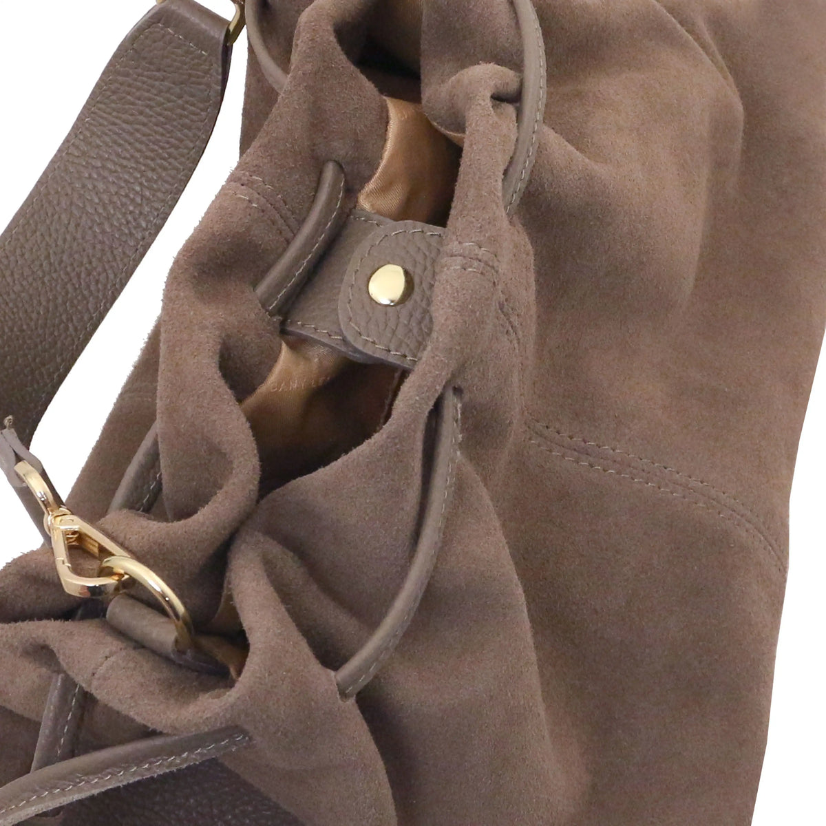 Close-up of a dark taupe suede slouchy shoulder bag with a leather strap and gold-tone hardware against a white background.