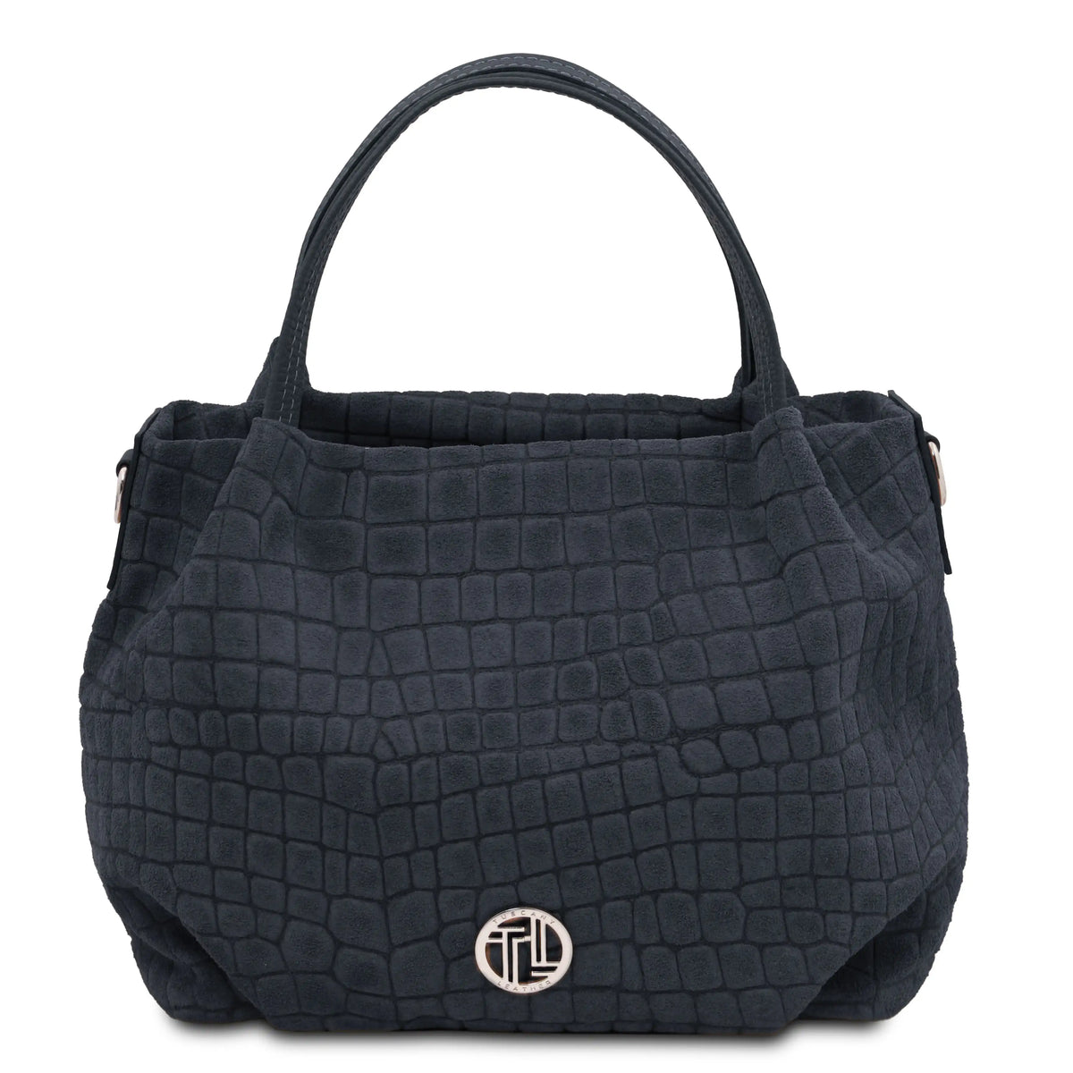 A dark blue textured handbag with a crocodile-embossed pattern, featuring dual top handles and a silver-toned circular logo medallion on the front, set against a plain white background.