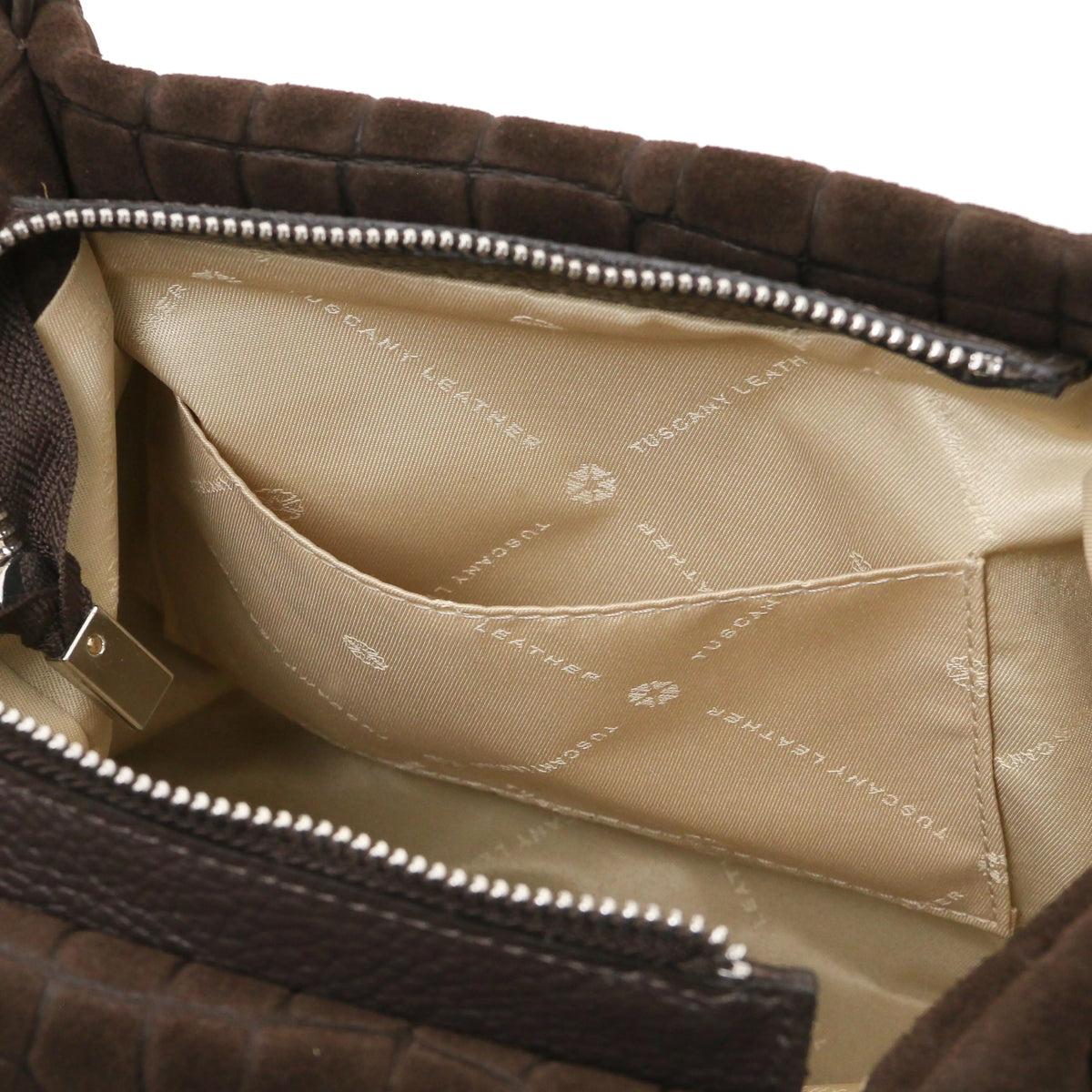 Close-up open pocket view of the interior of a chocolate croc print leather bag, showing a bright red lining with 'TUSCANY LEATHER' printed branding,