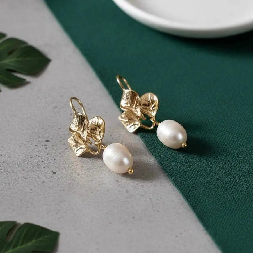 Amalfi Golden Daisy Earrings laying on a green table linen