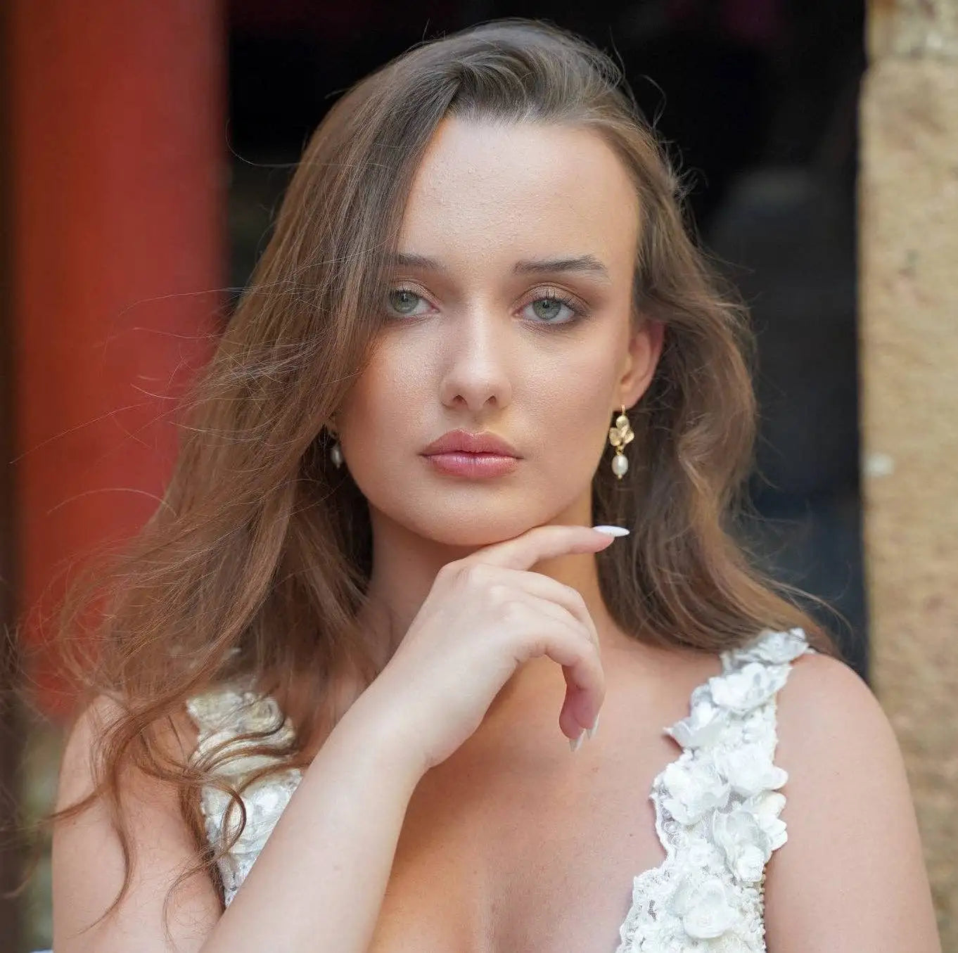 A woman with long light brown hair wearing the Amalfi Golden Daisy Earrings