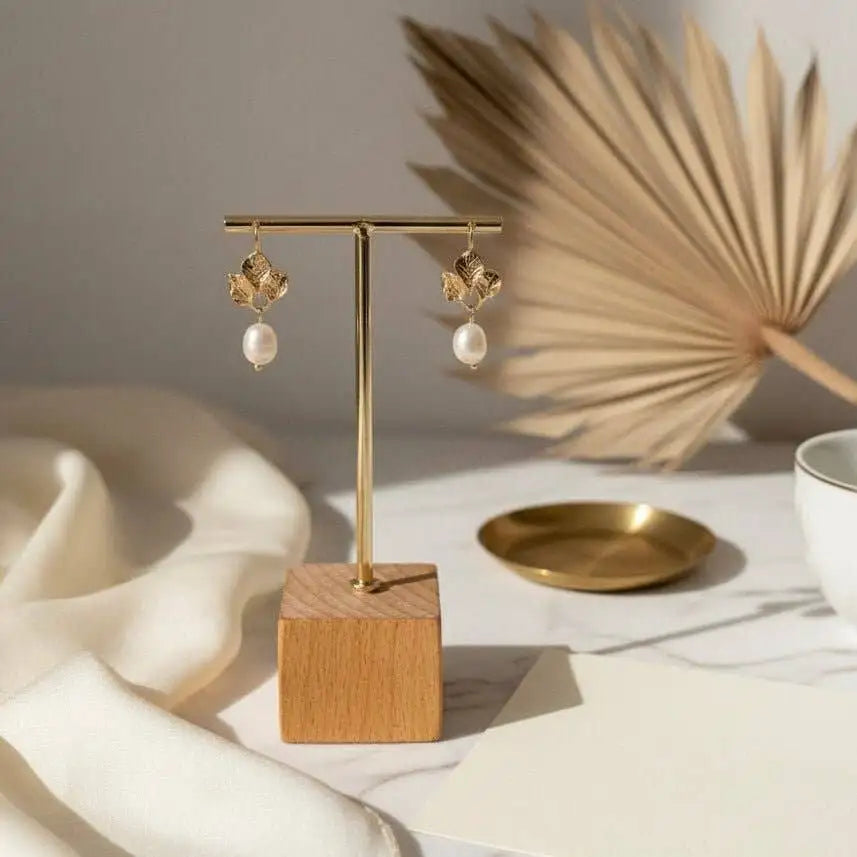 Amalfi Golden Daisy Earrings styled on a jewelry table stand