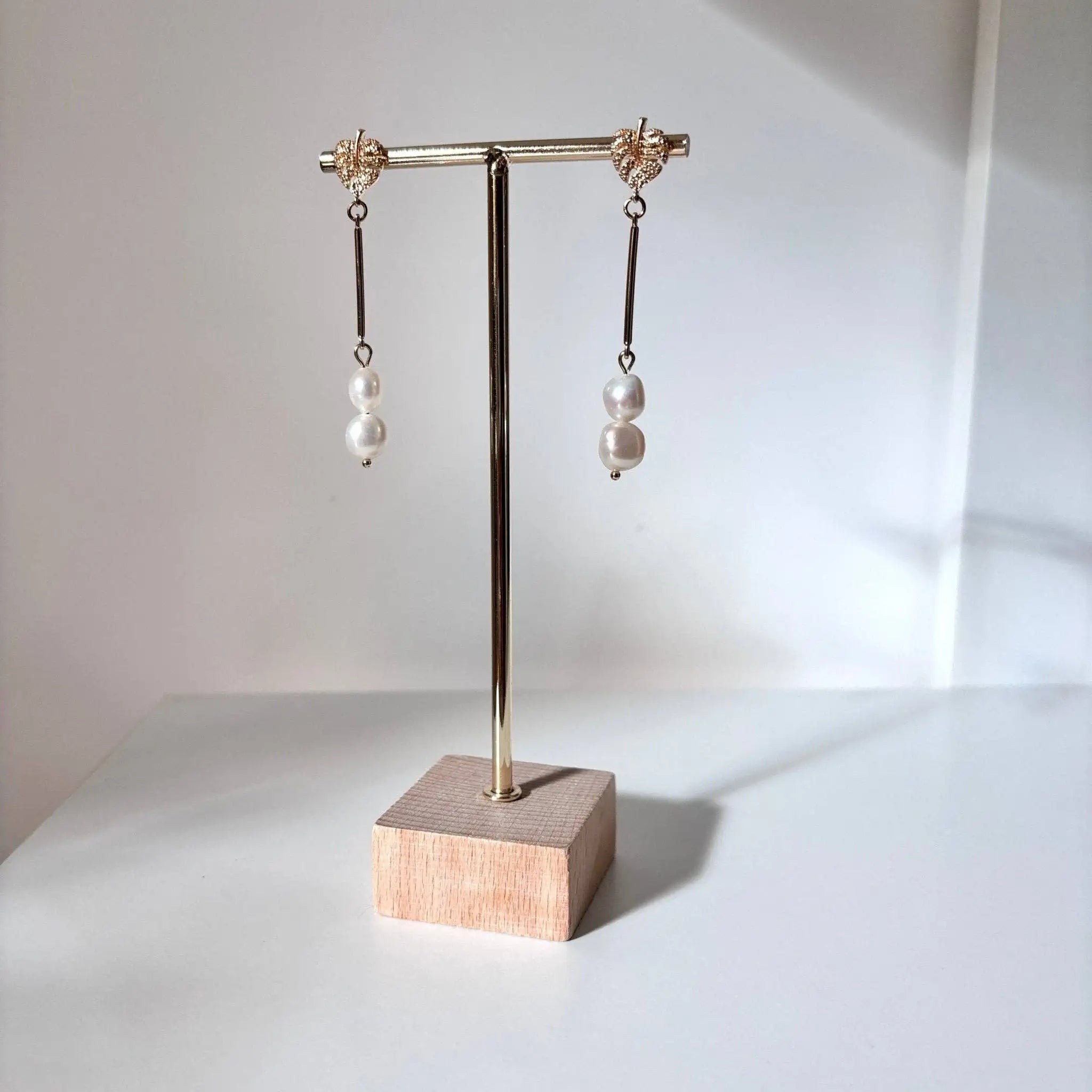 Amalfi Monstera Leaf Drop Earrings on a jewelry stand with a neutral background
