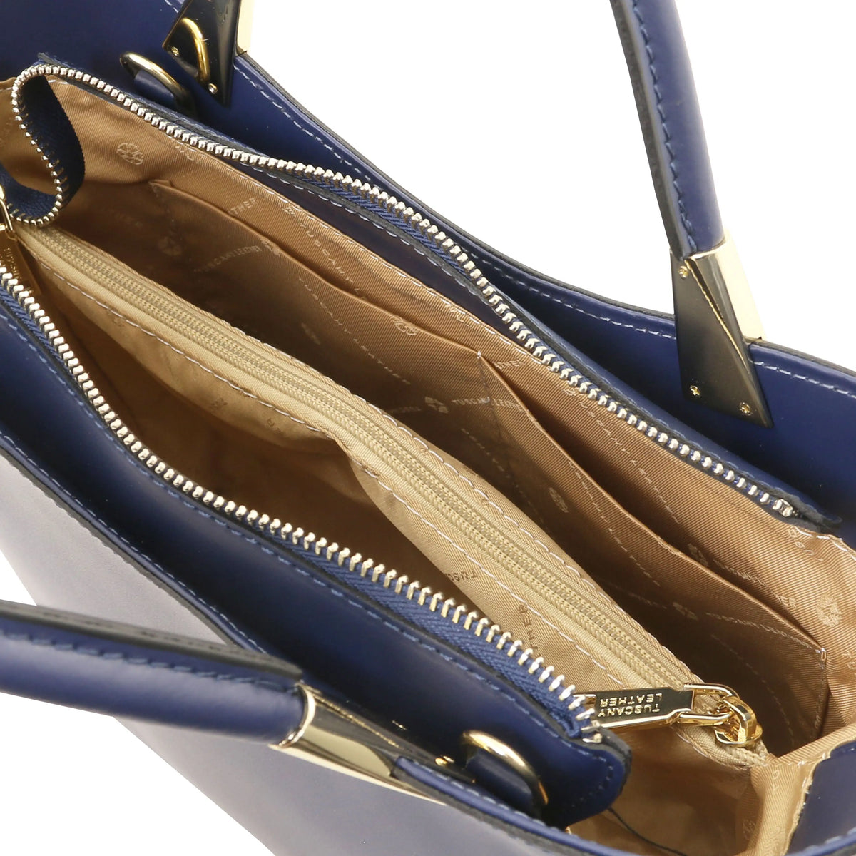 Close-up of a dark blue handbag interior showing a beige zippered compartment, gold-tone zippers, and a small gold brand tag that reads EATON.