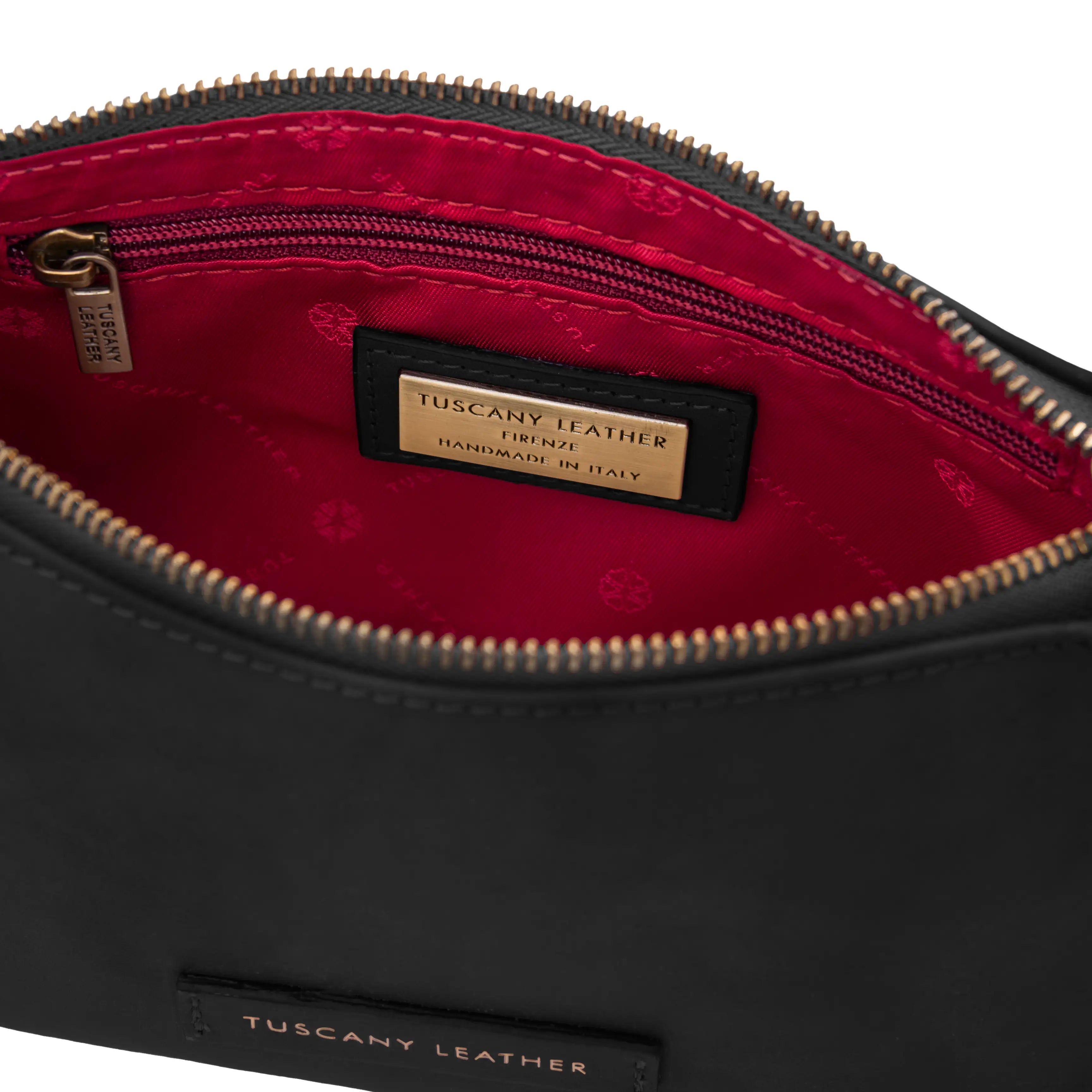 Black leather bag with red interior and Tuscany Leather label on a white background