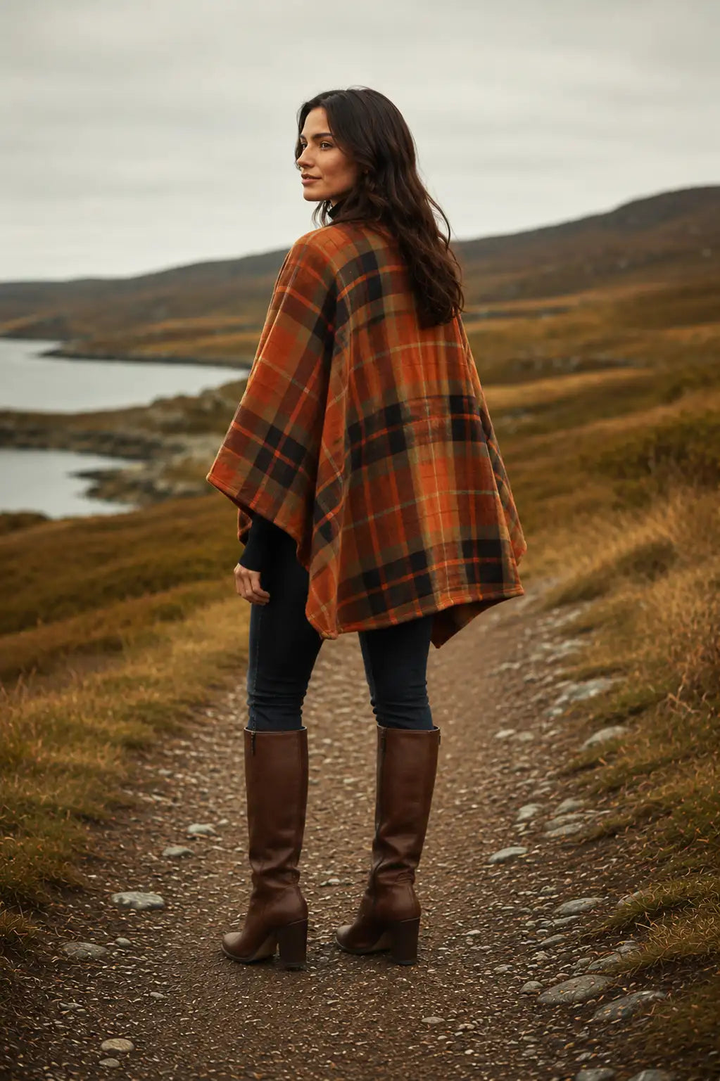 Woman in the Irish Autumn Spice Ruana Wrap and brown boots standing on a path with a scenic background.