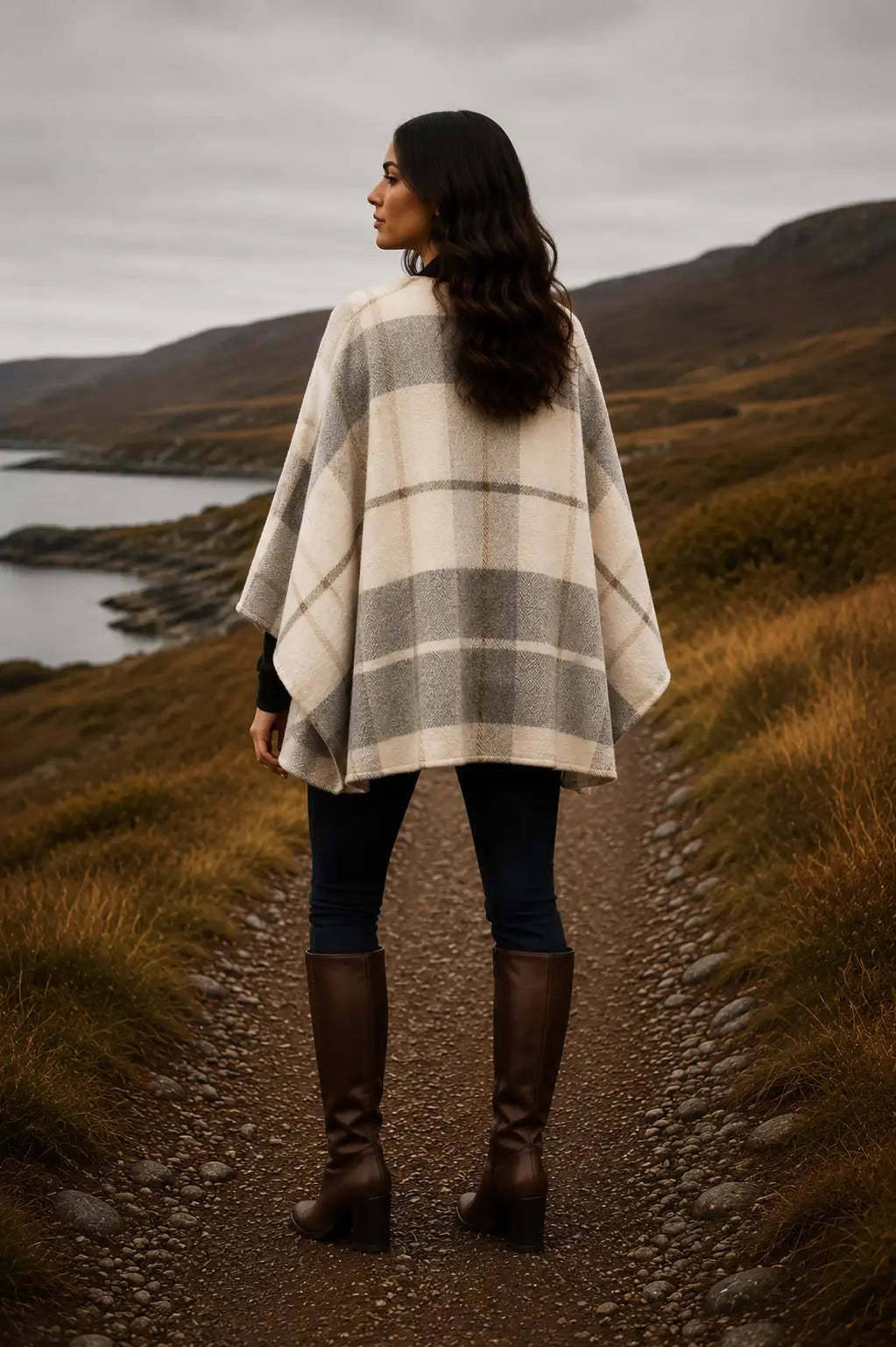 Woman in Irish Winter Tartan Ruana Wrap standing on a path with mountains and water in the background
