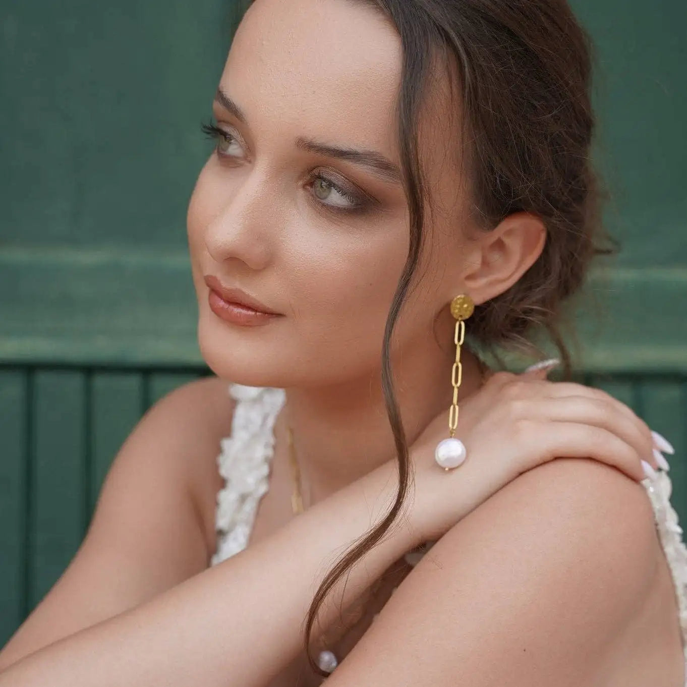 Close up of a woman with her brown hair wearing the Isabel Drop Earrings