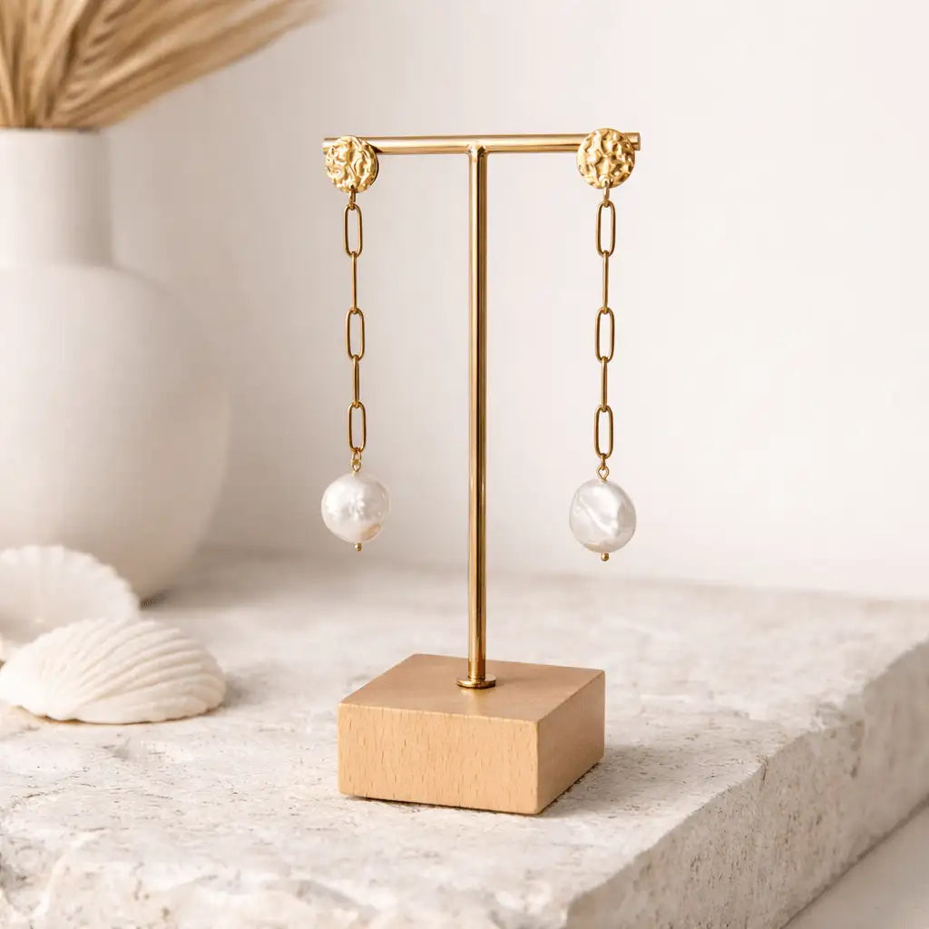 Isabel Drop Earrings on a jewelry stand with a natural background with shells