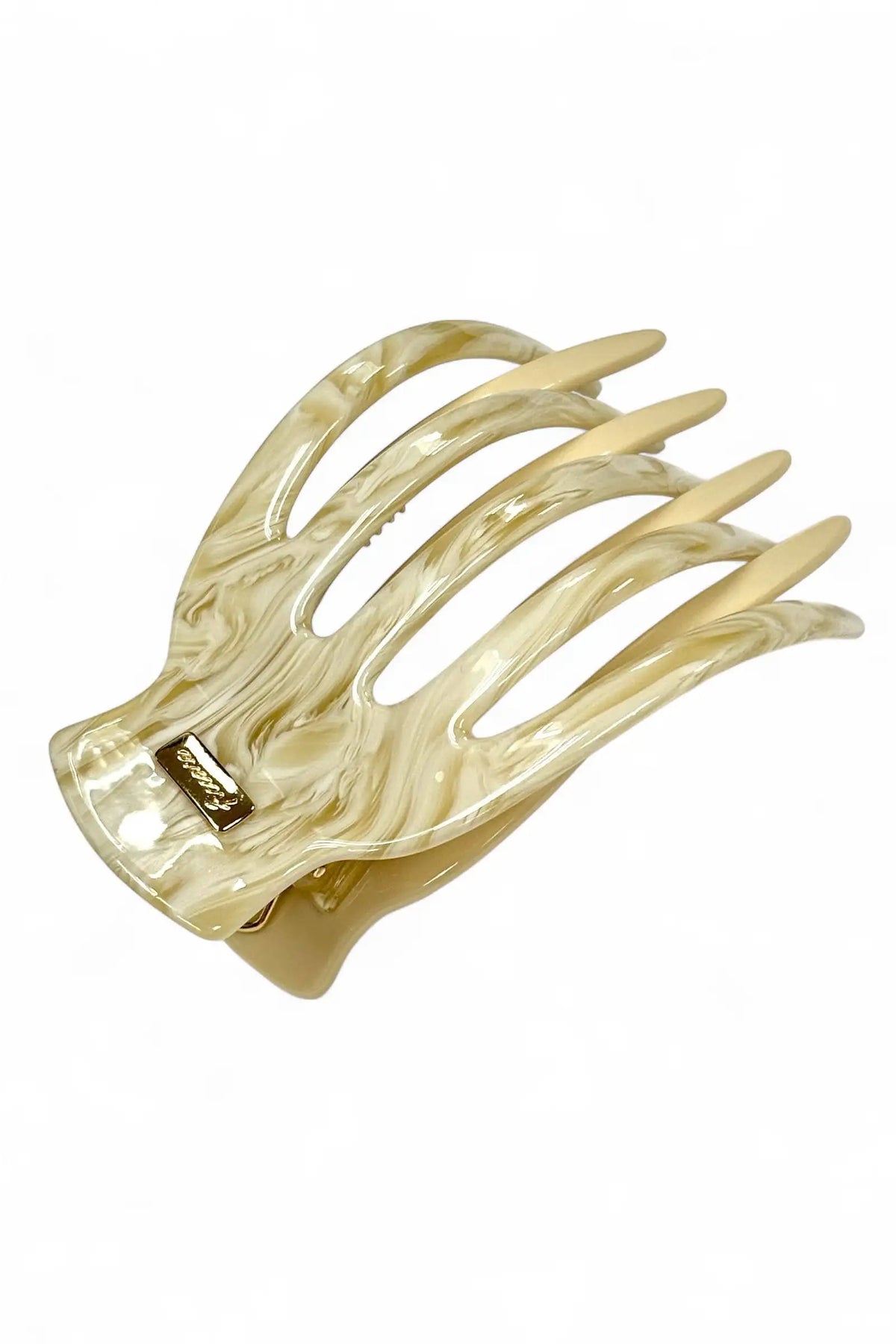 A single claw-style hair clip made of translucent marbled acetate in warm cream and beige tones, shown on a plain white background.