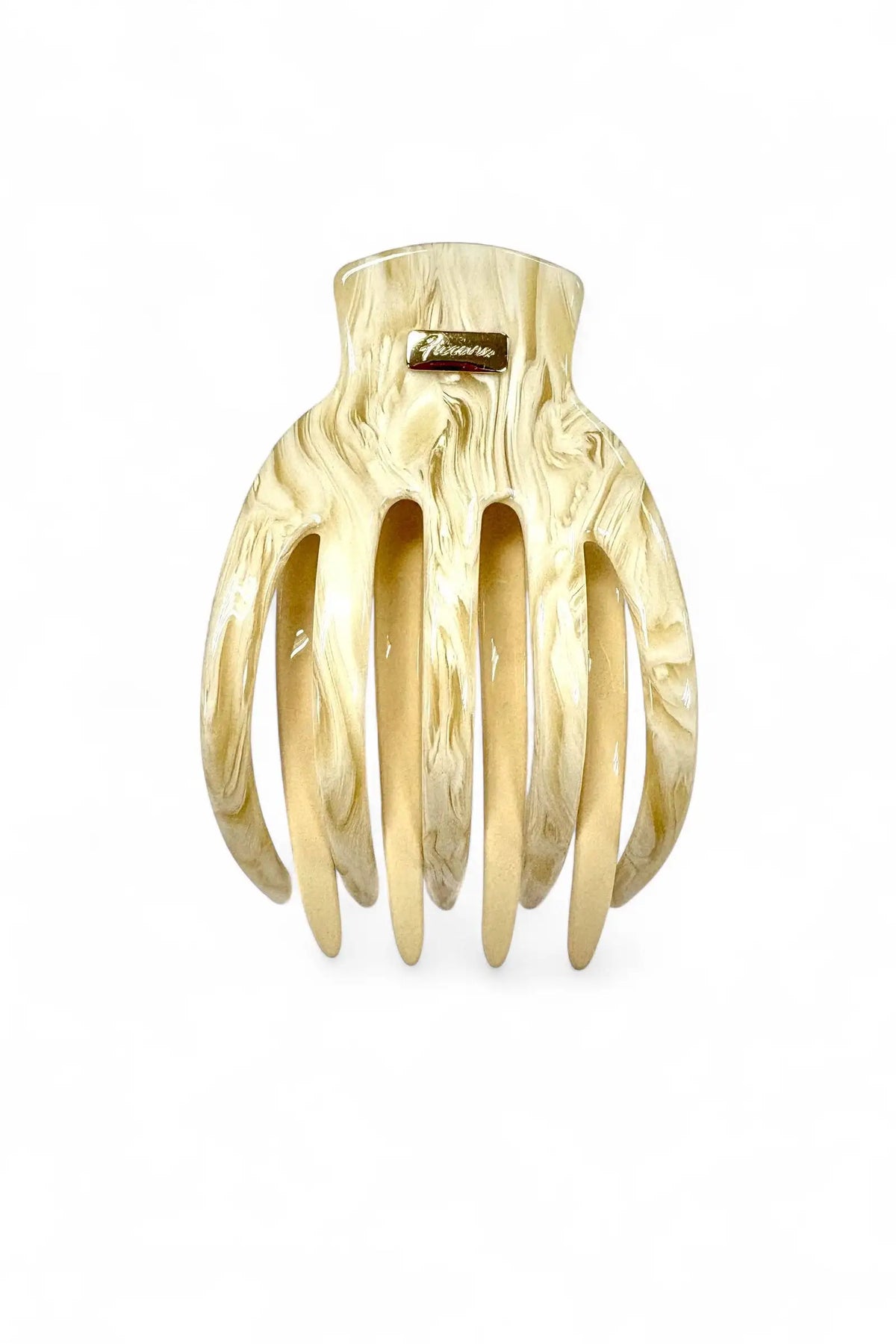 A large claw-style hair comb made of glossy, marbled cream and light brown resin, featuring a small gold-tone brand plaque on the back, set against a plain white background.