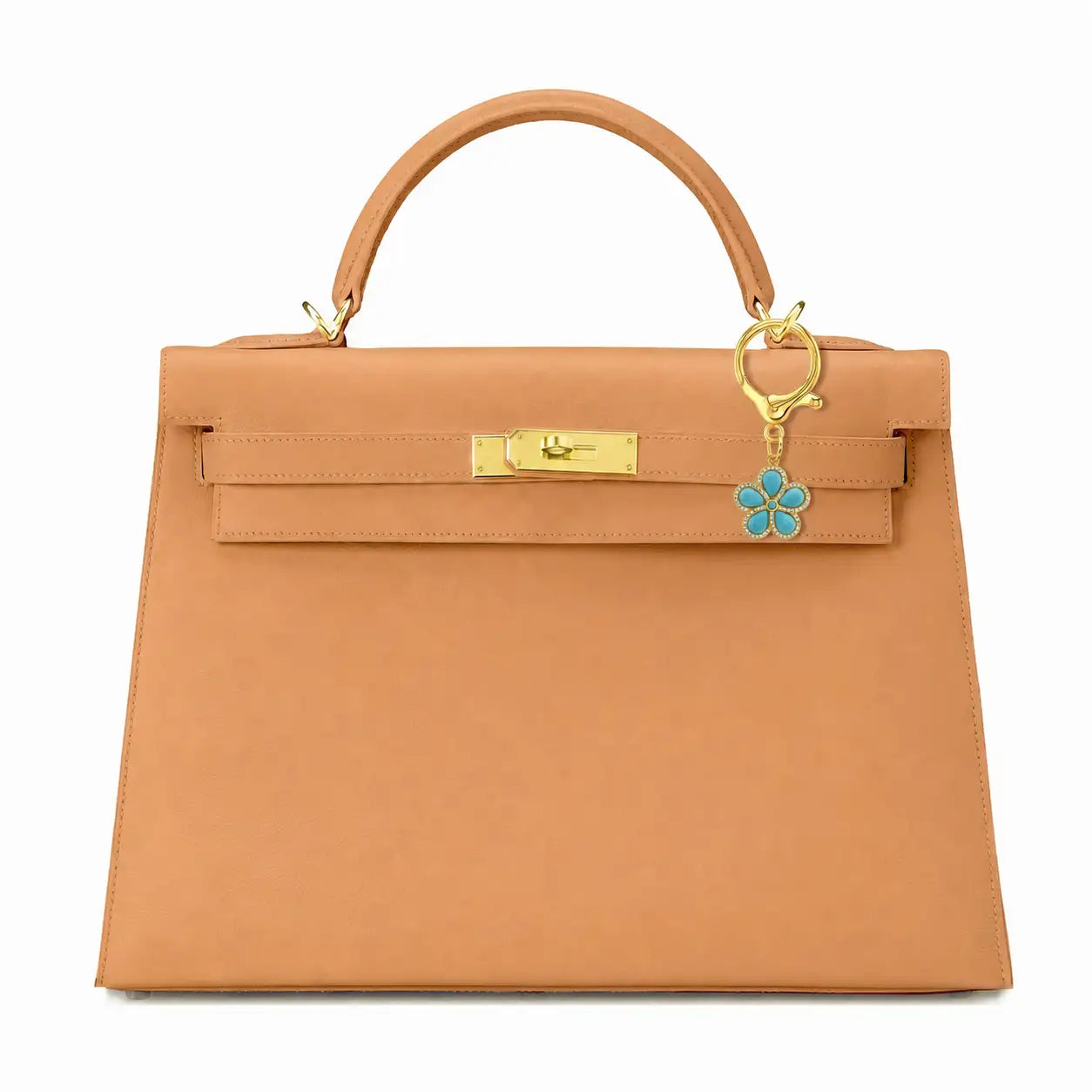 A structured tan leather handbag with a top handle, gold-tone hardware, and a turquoise and gold flower bag charm, shown against a plain white background.