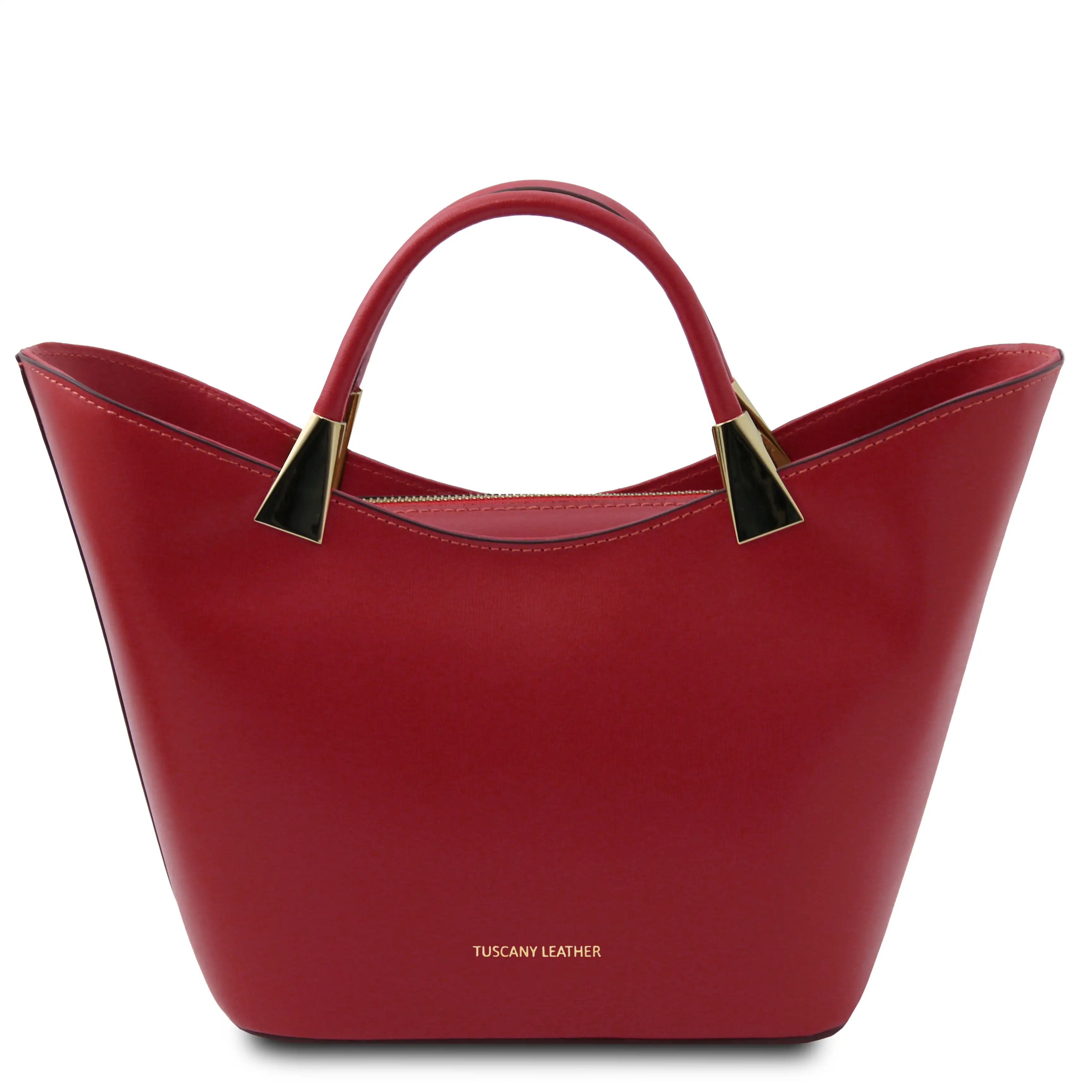 A red leather handbag with a structured sculpted silhouette, dual top handles, and gold-tone hardware, shown on a plain white background. The brand name 'TUSCANY LEATHER' is printed in gold near the bottom center.