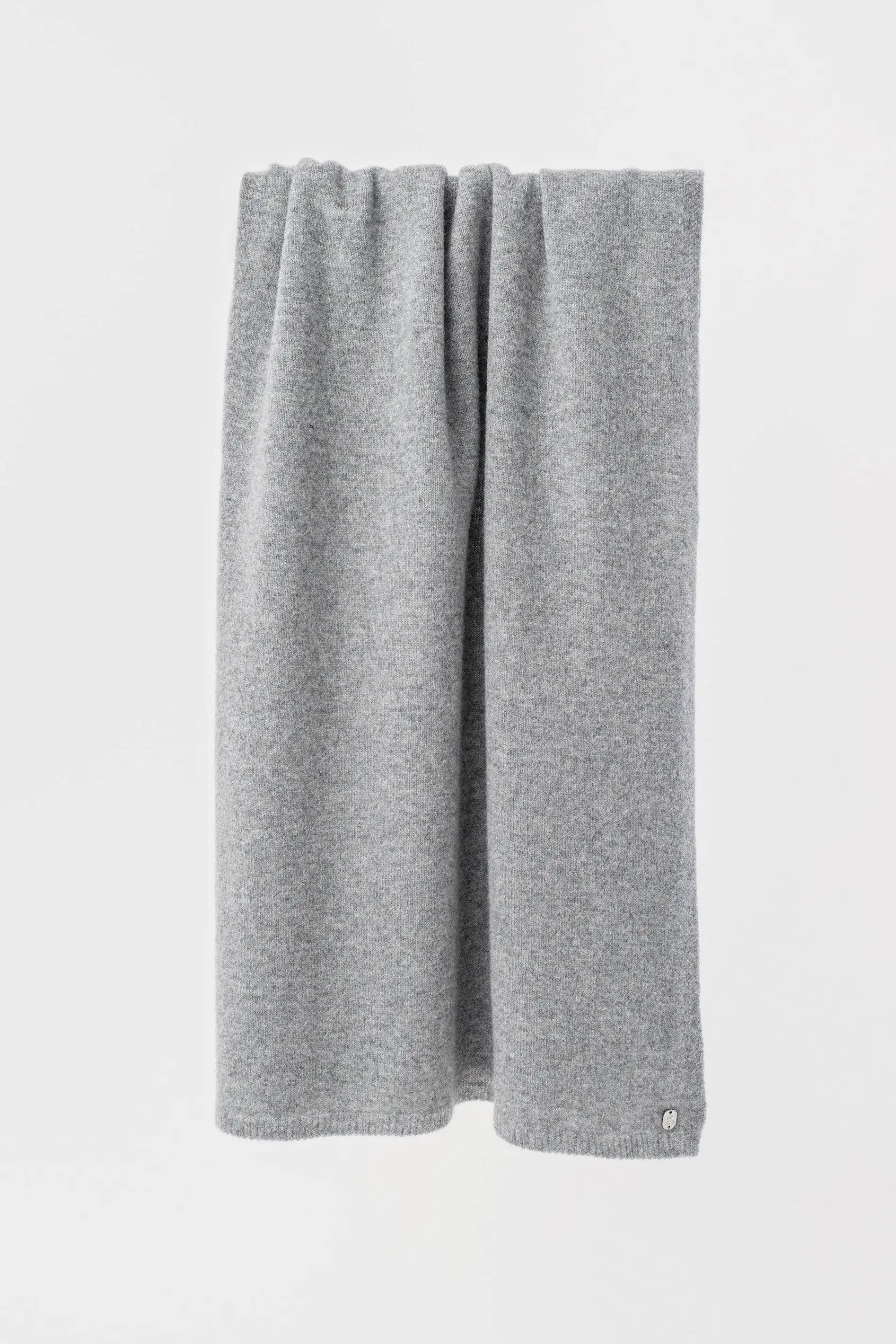 A light gray knit scarf draped vertically against a plain white background.
