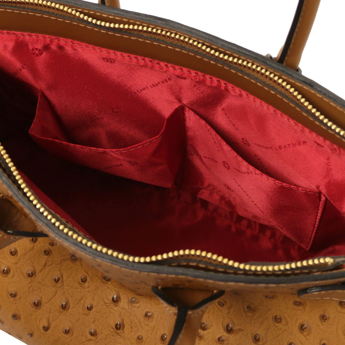 Cognac leather ostrich print handbag with interior open pockets and red lining on a white background