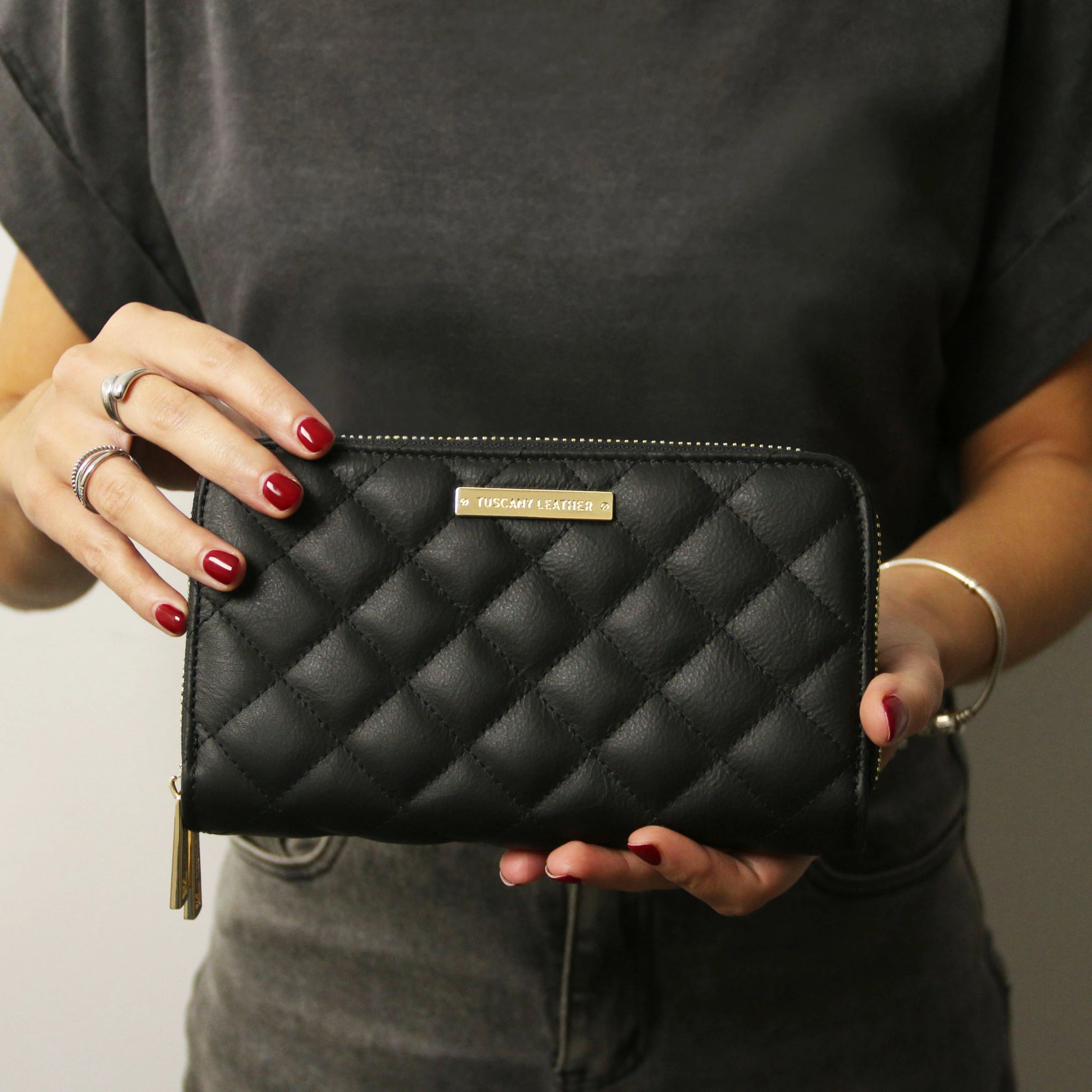 Women with red fingernail polish holding the Ada Double Zip Around Soft Italian Leather Wallet in Black