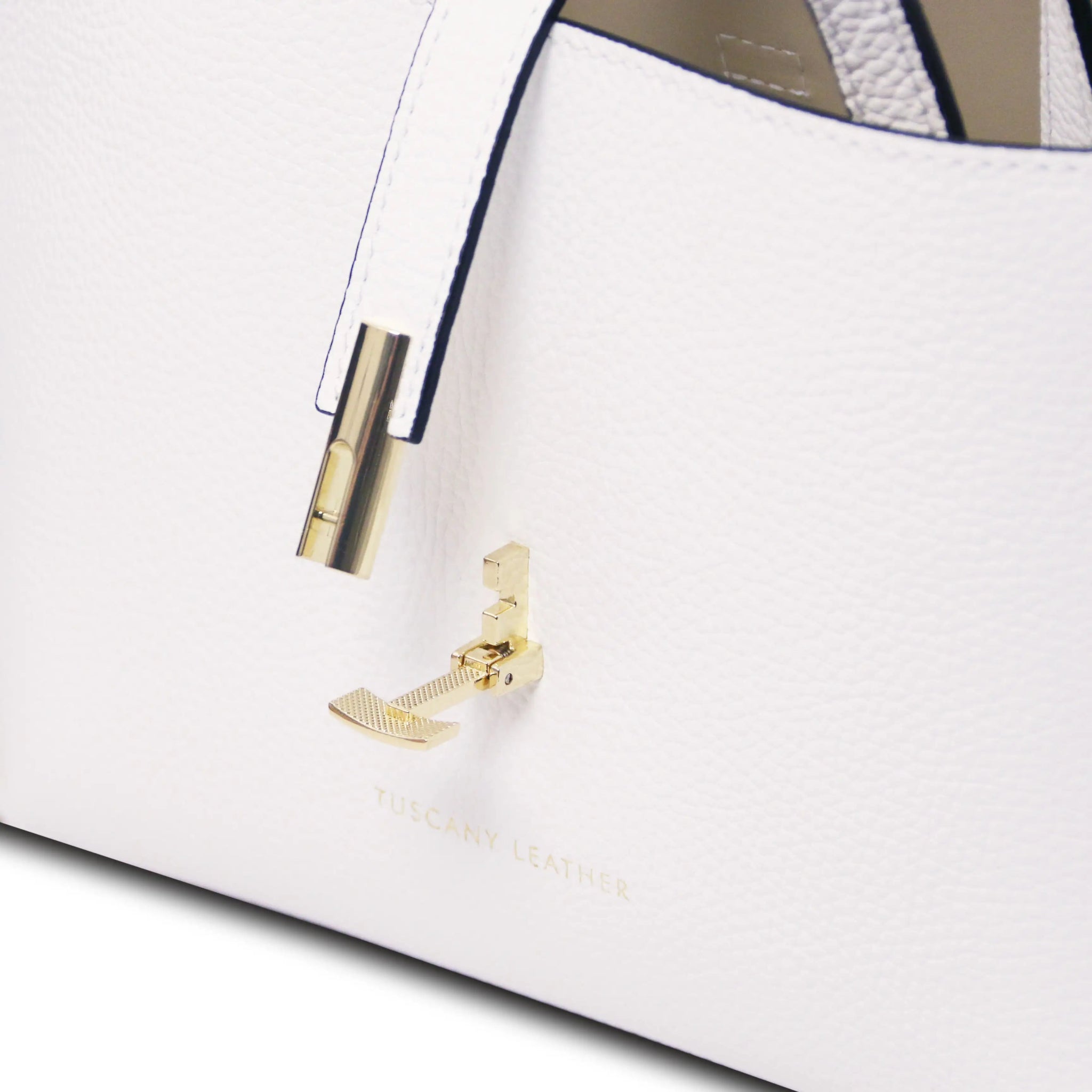 Close-up of a white handbag with gold clasp on a white background