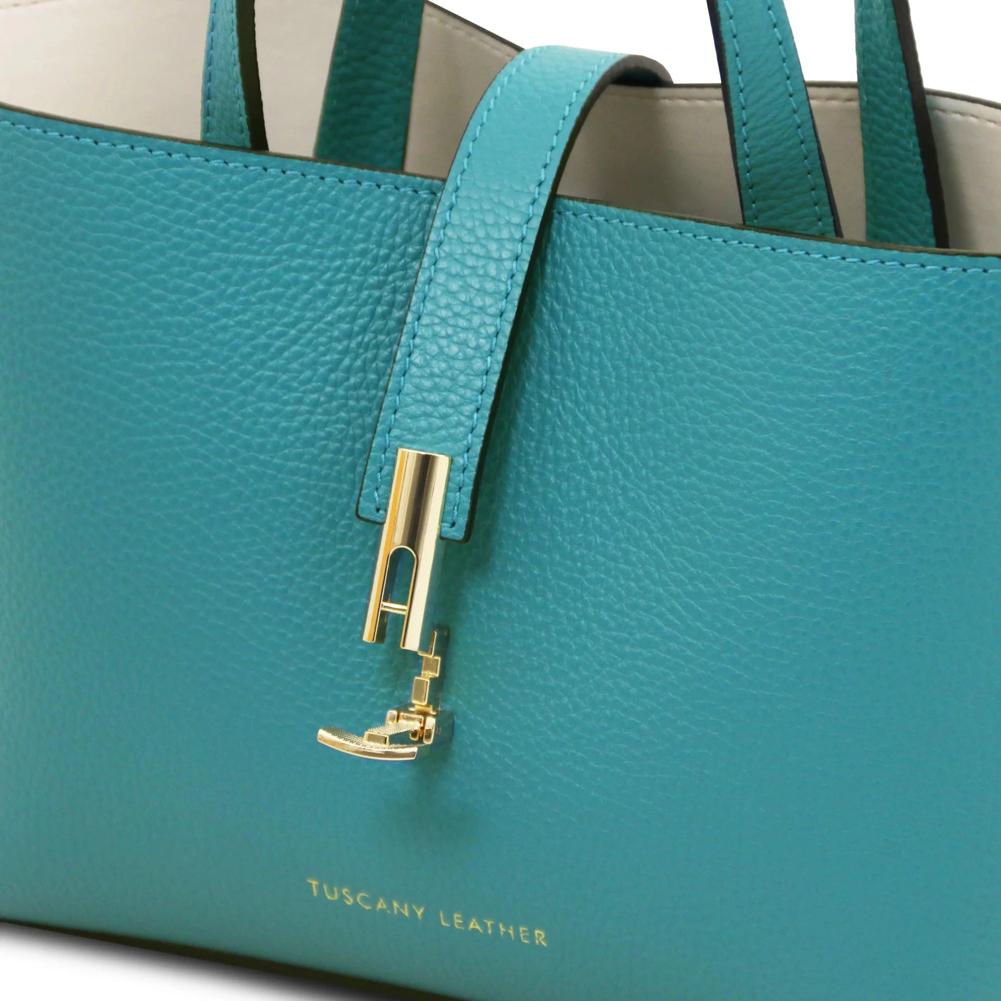 Turquoise leather handbag with gold twist clasp lock and 'Tuscany Leather' branding.