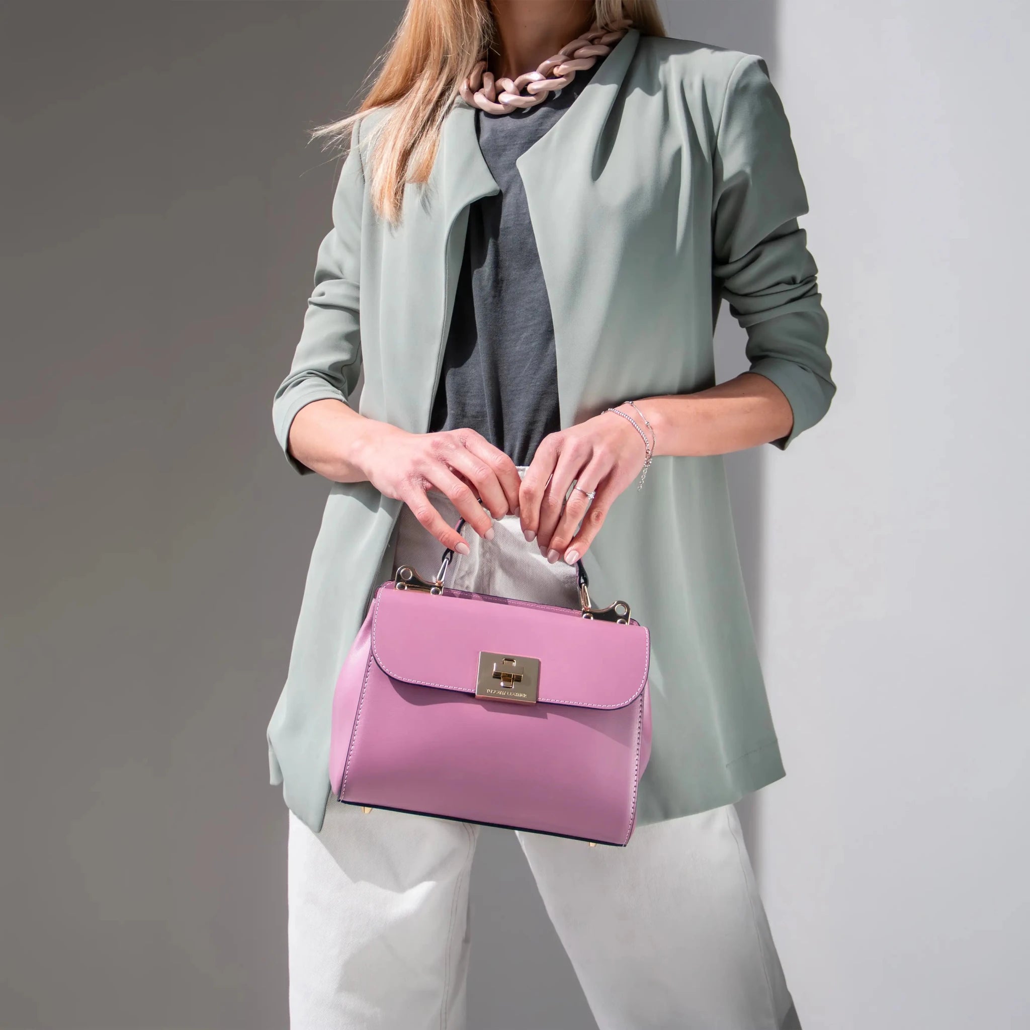 Woman wearing a seafoam silky long vest holding Armonia Handbag in Lilac
