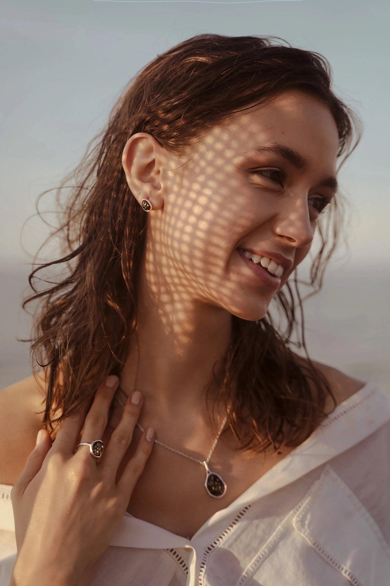 Baltic Green Amber Element Silver Pendant Necklace and stud earrings on a female model