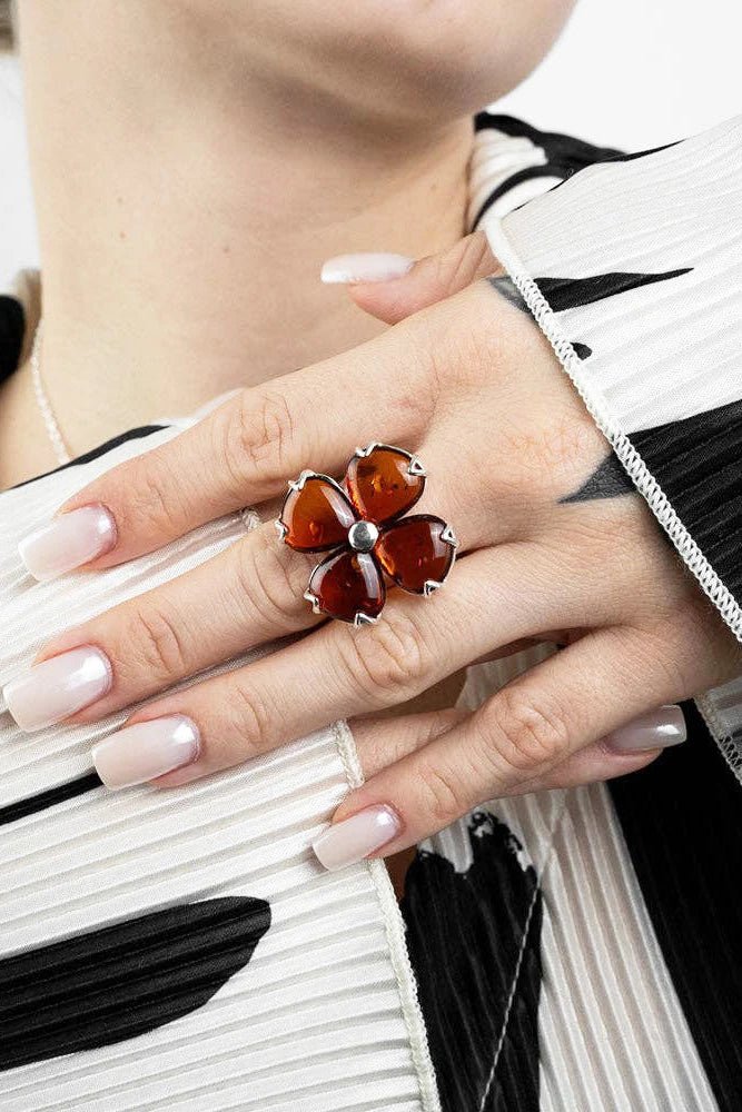 A model is wearing the Baltic Honey Amber Daisy Adjustable Sterling Silver Ring