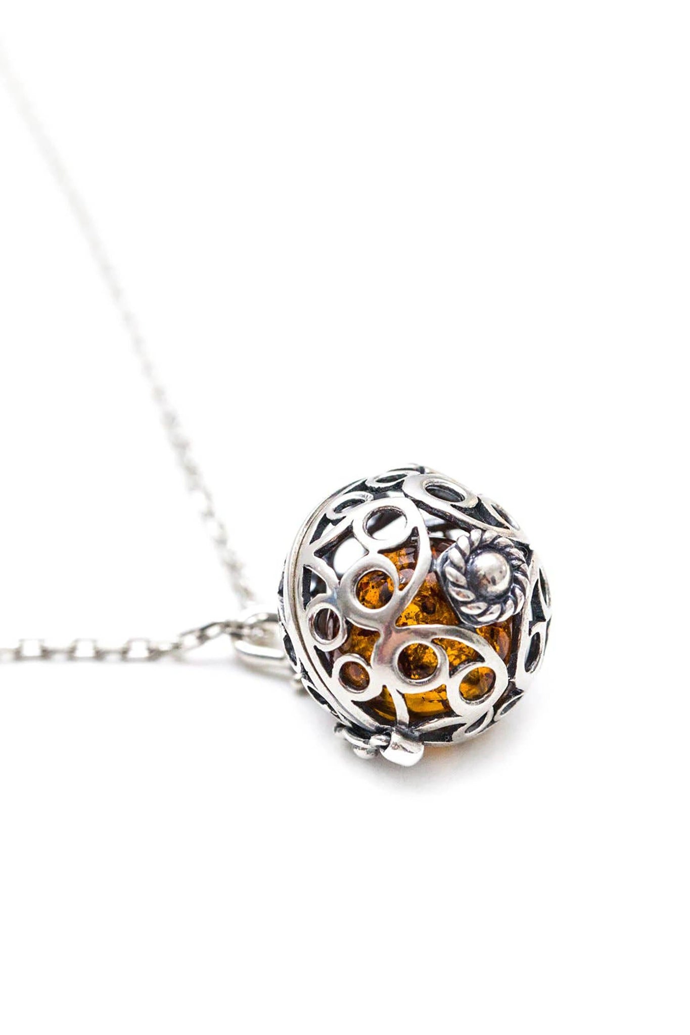 Baltic Honey Amber Sterling Silver Filigree Locket Necklace pendant is closed in front of a white background
