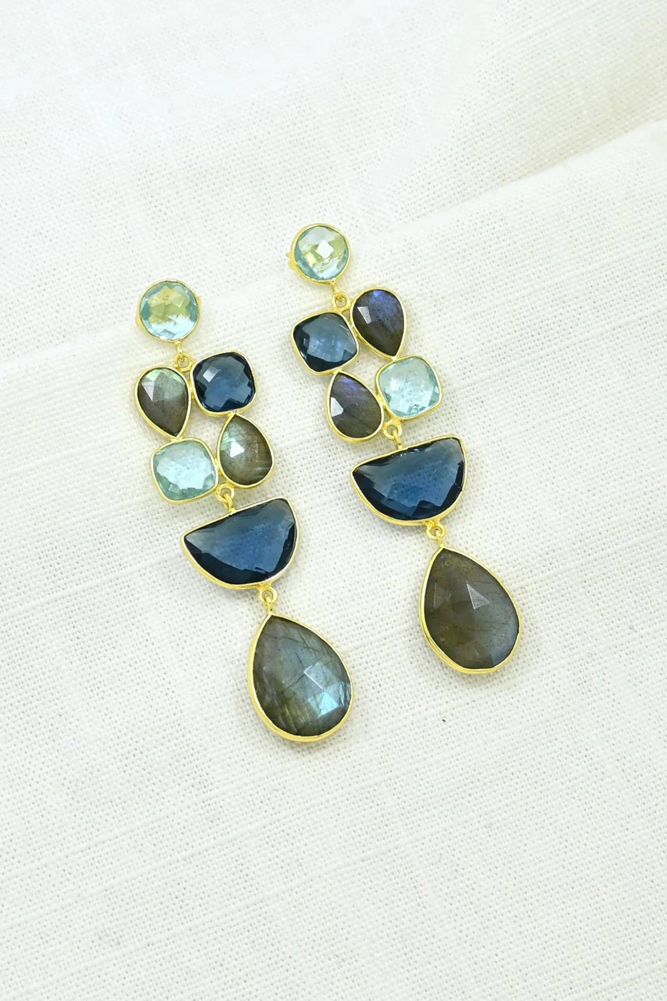 Earrings with blue and green gemstones on a natural background