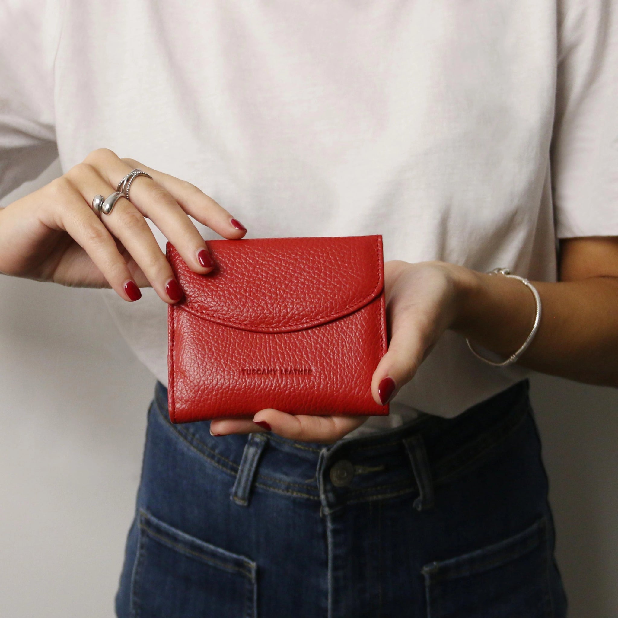 Calliope Exclusive 3 Fold Italian Leather Wallet in Lipstick Red held by a female model