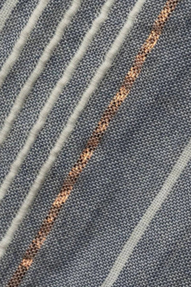 Close-up of a fabric with blue and white striped pattern and brown stitching.