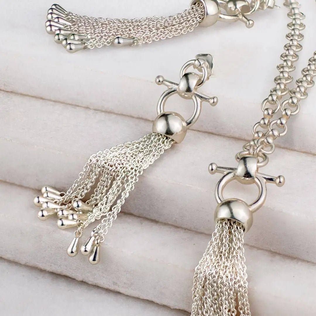 Chantilly Horse Bit Tassel Silver Necklaces and Earrings Styled on a light gray surface