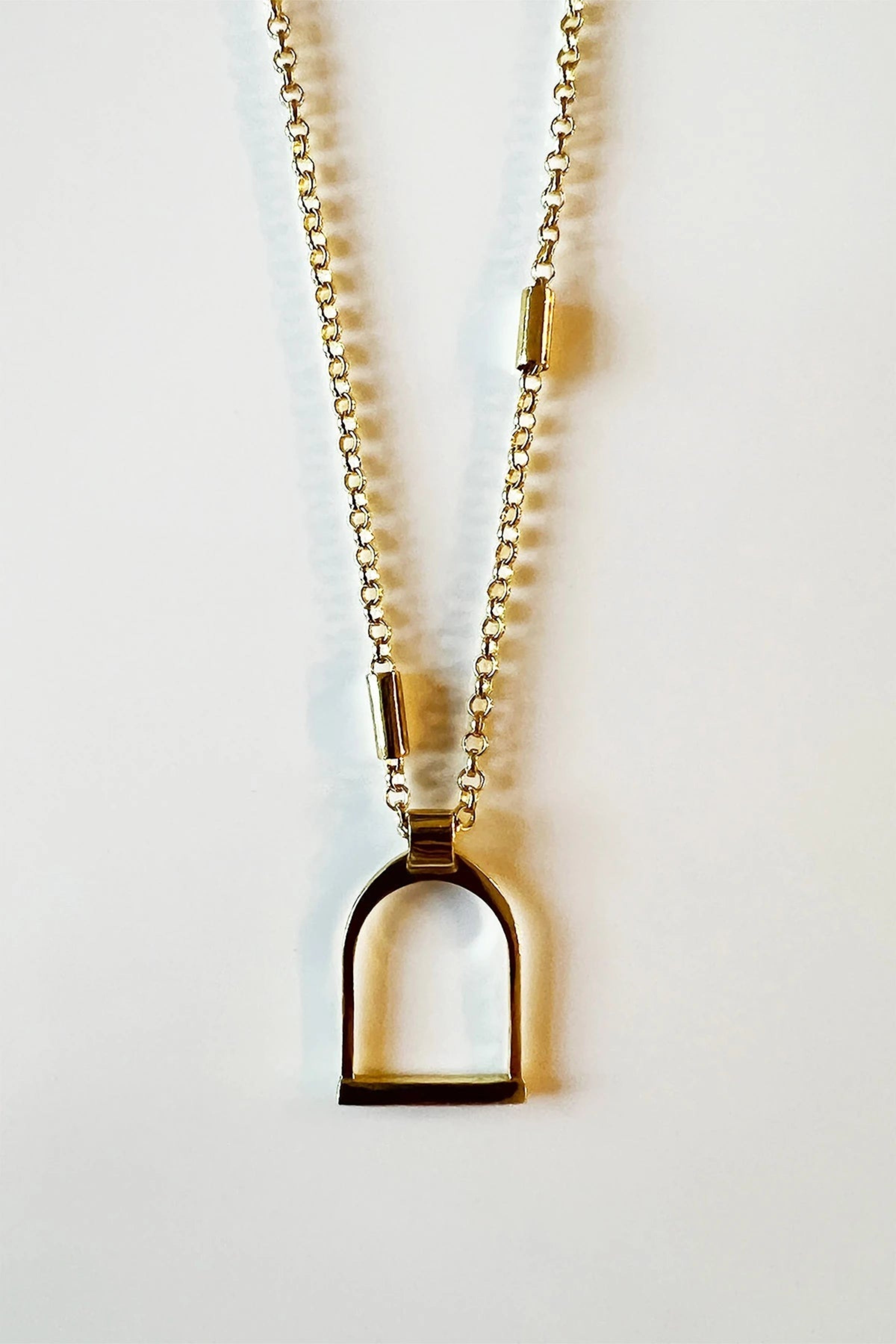 Classic English Stirrup Necklace in Gold on a white background - L'Atelier Global