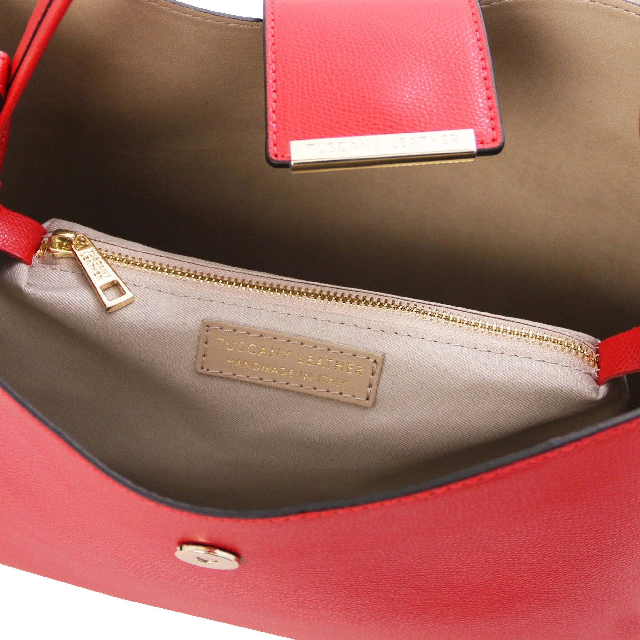 Exterior top view central zippered compartment, magnetic button closure and light tsn lining of the Clio Italian Pebbled Leather Secchiello Bag in red