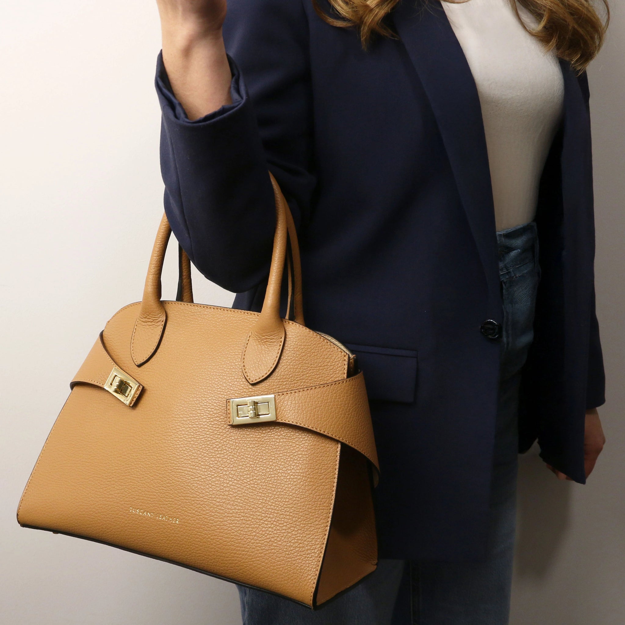 Model is holding Coccola Italian Pebbled Leather Handbag in Caramel