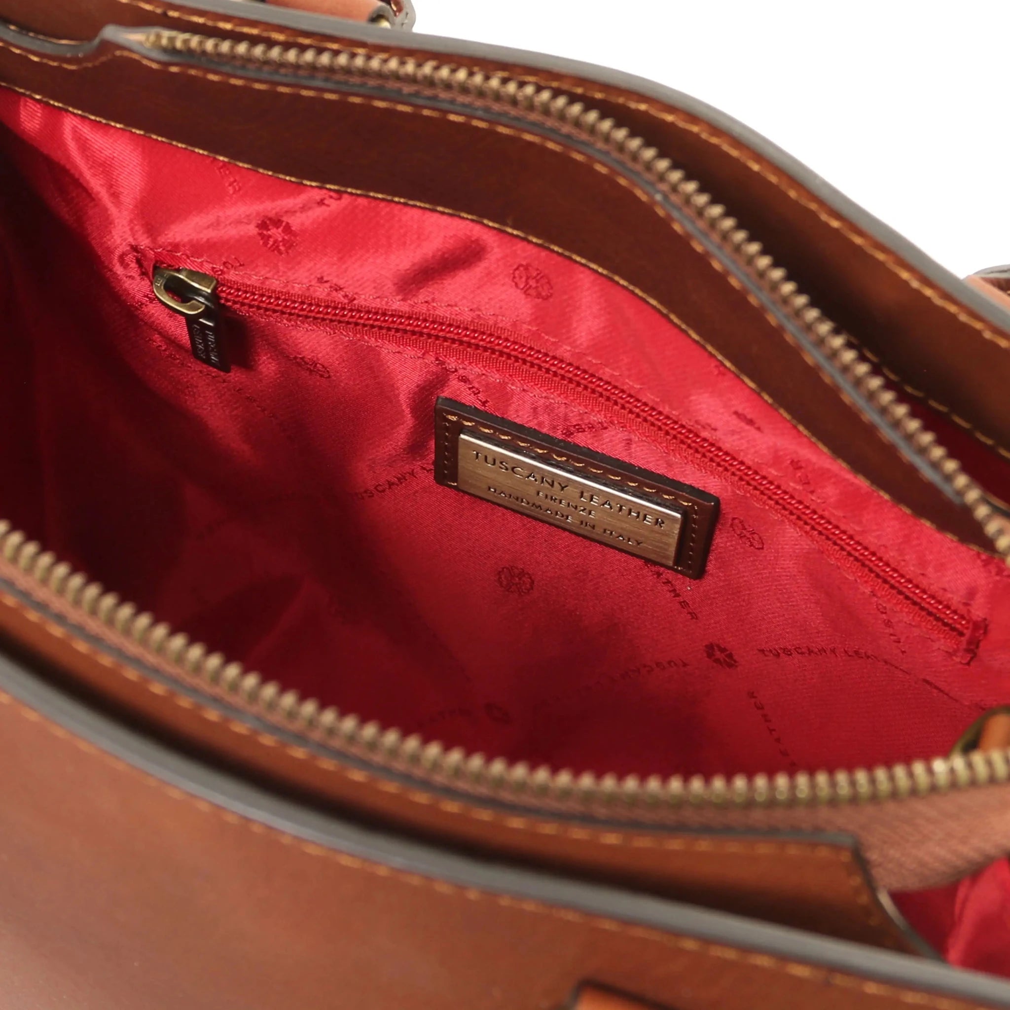 Interior zip pocket red lining view Dama Leather Handbag in brown