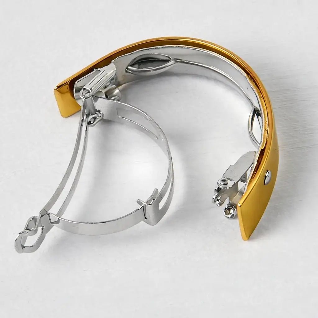 Gold and silver metal hair barette on a qwhite background