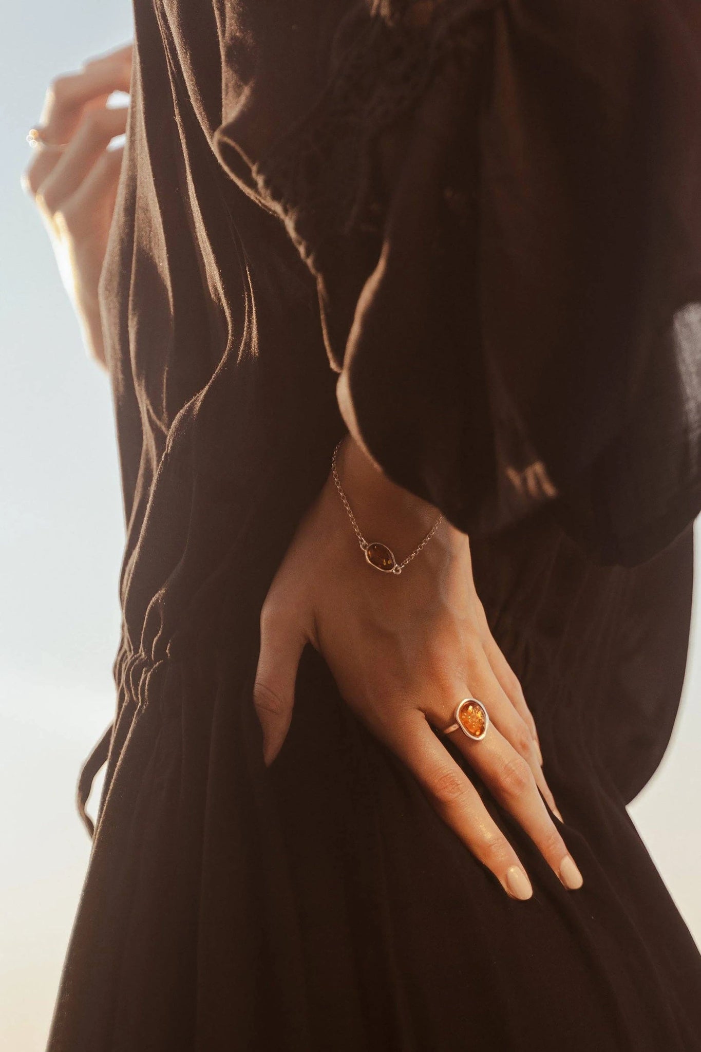 A female model's hands are wearing the Honey Baltic Amber Element Solitaire Adjustable Ring