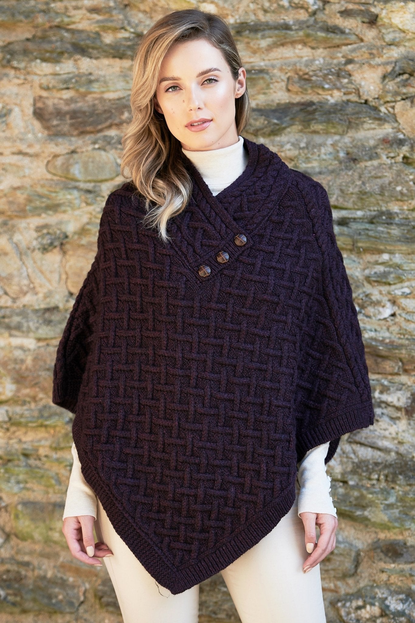 Irish Connemara Supersoft Merino Wool Poncho in dark plum on a model. Three fixed buttons are showcased on the chest