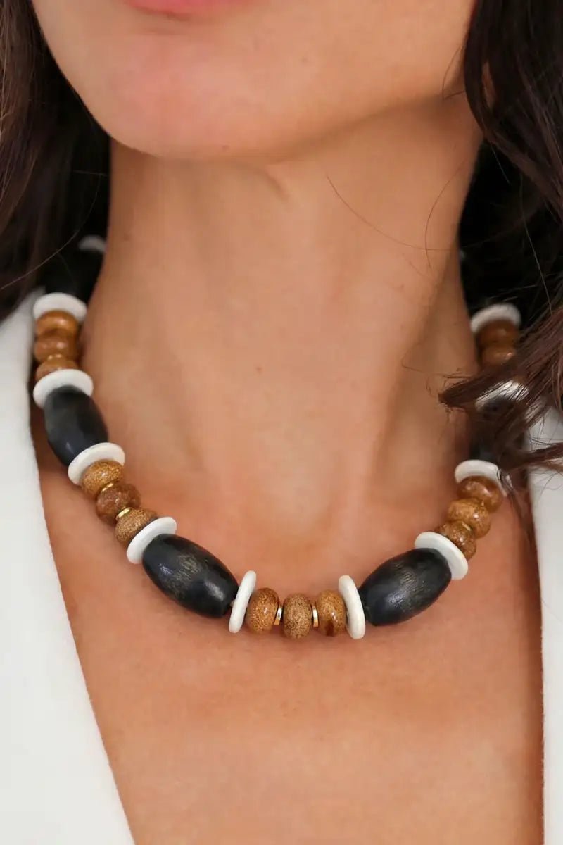 Close up of a woman's neck wearing the Jave necklace with a white blouse