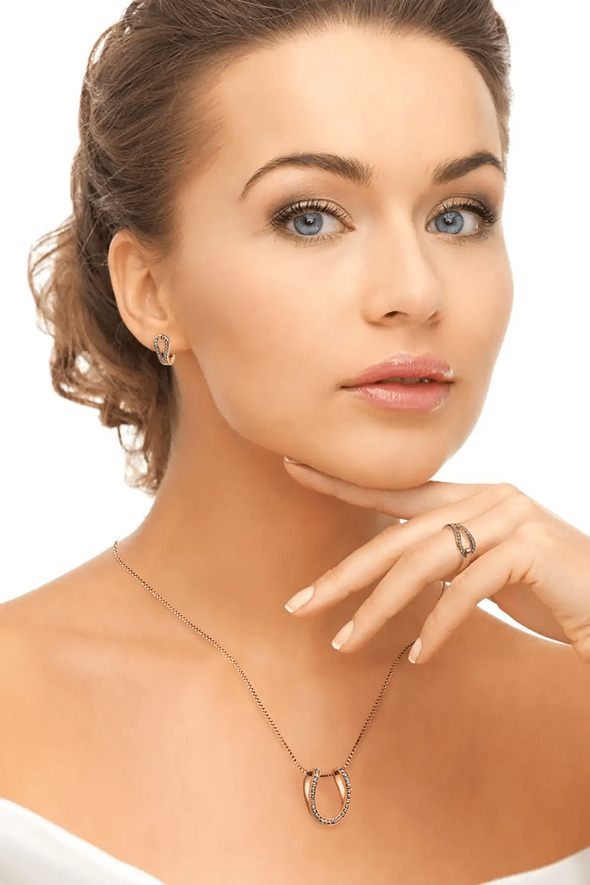 Woman wearing a necklace with a gold horseshoe pendant on a white background
