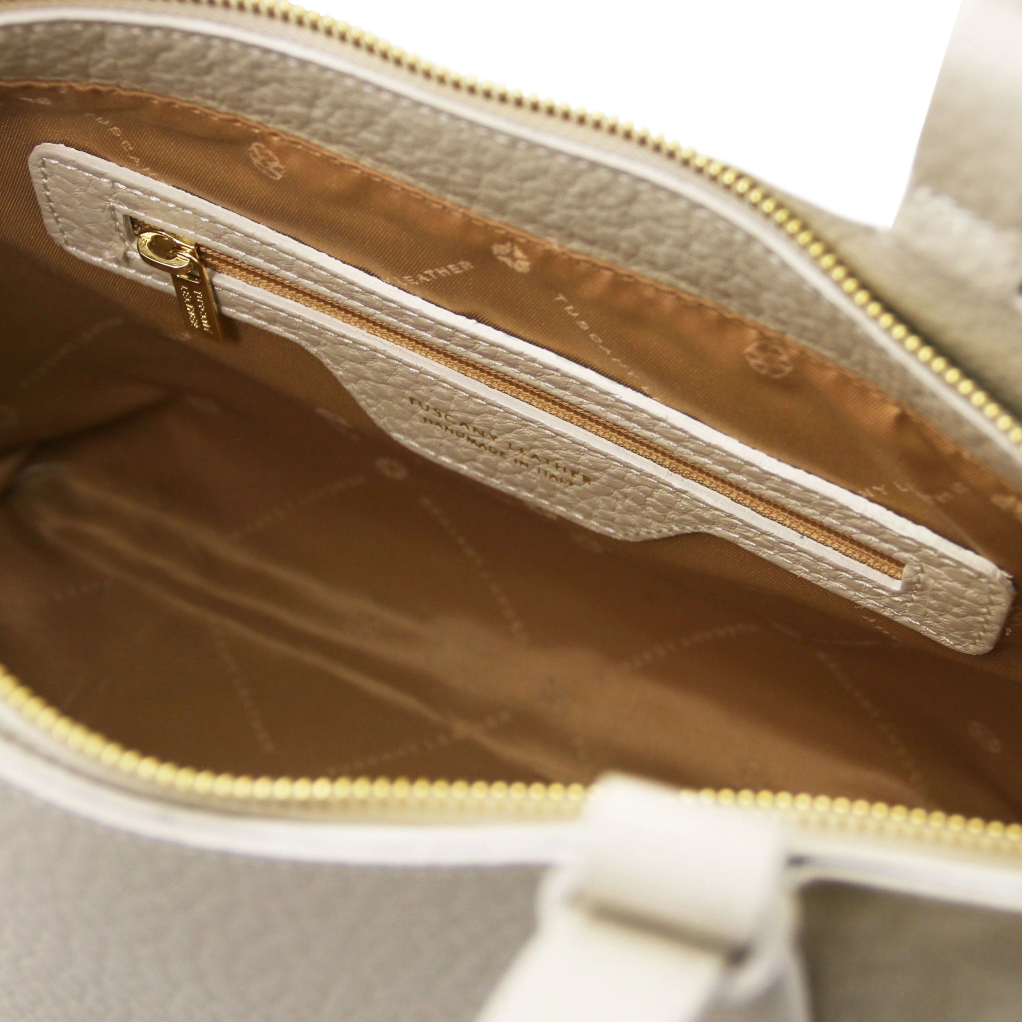 Interior zip pocket of the Libra Leather Suede Shoulder Bag in beige with tan lining and gold zipper.