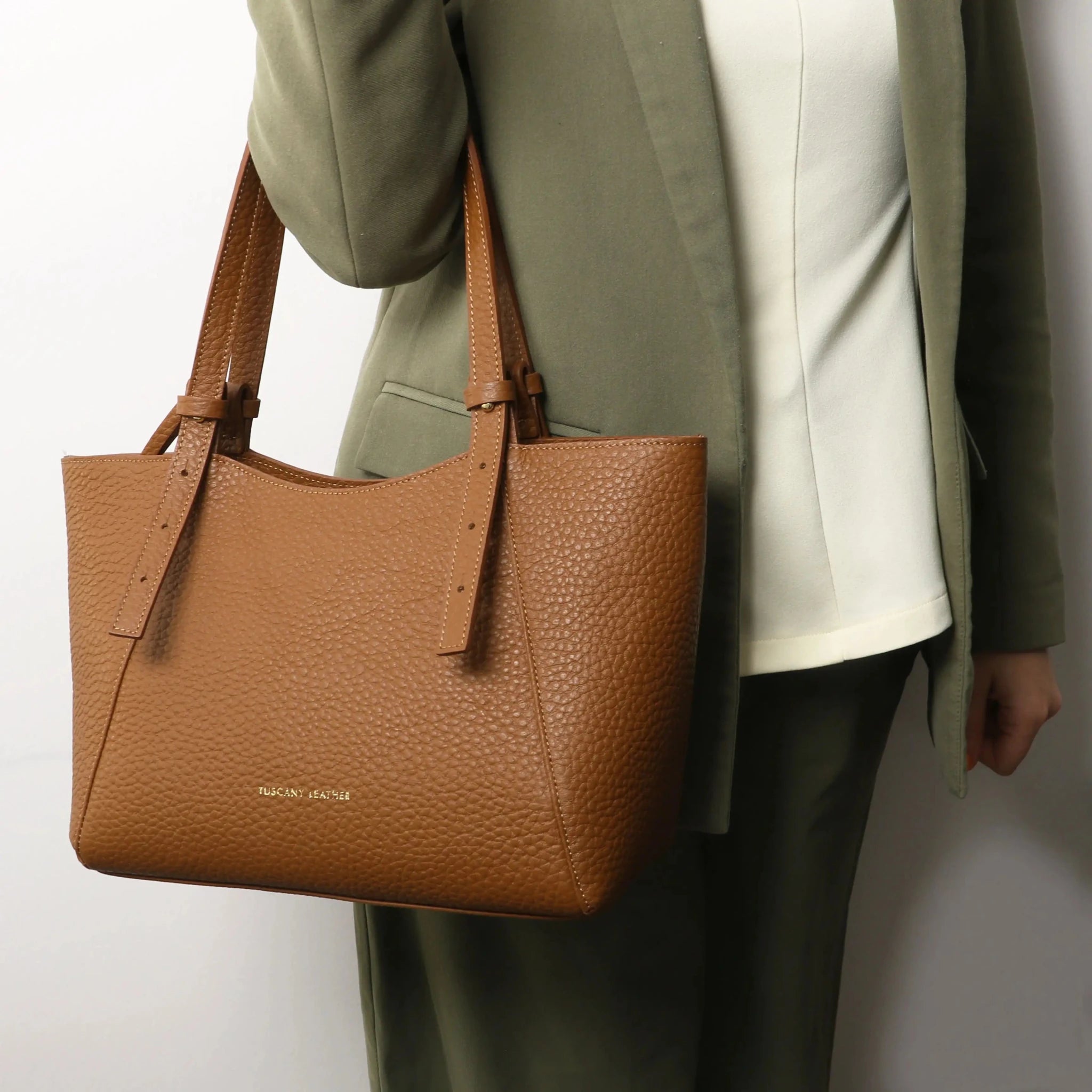 Person holding the Libra Leather Shoulder Bag in cognac