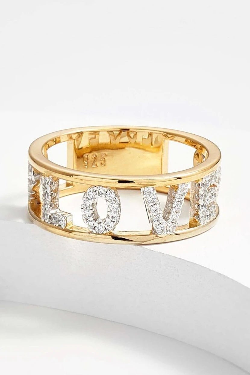 Love Golden Eternity Ring on a white background, the word love can be seen glistening - L'Atelier Global