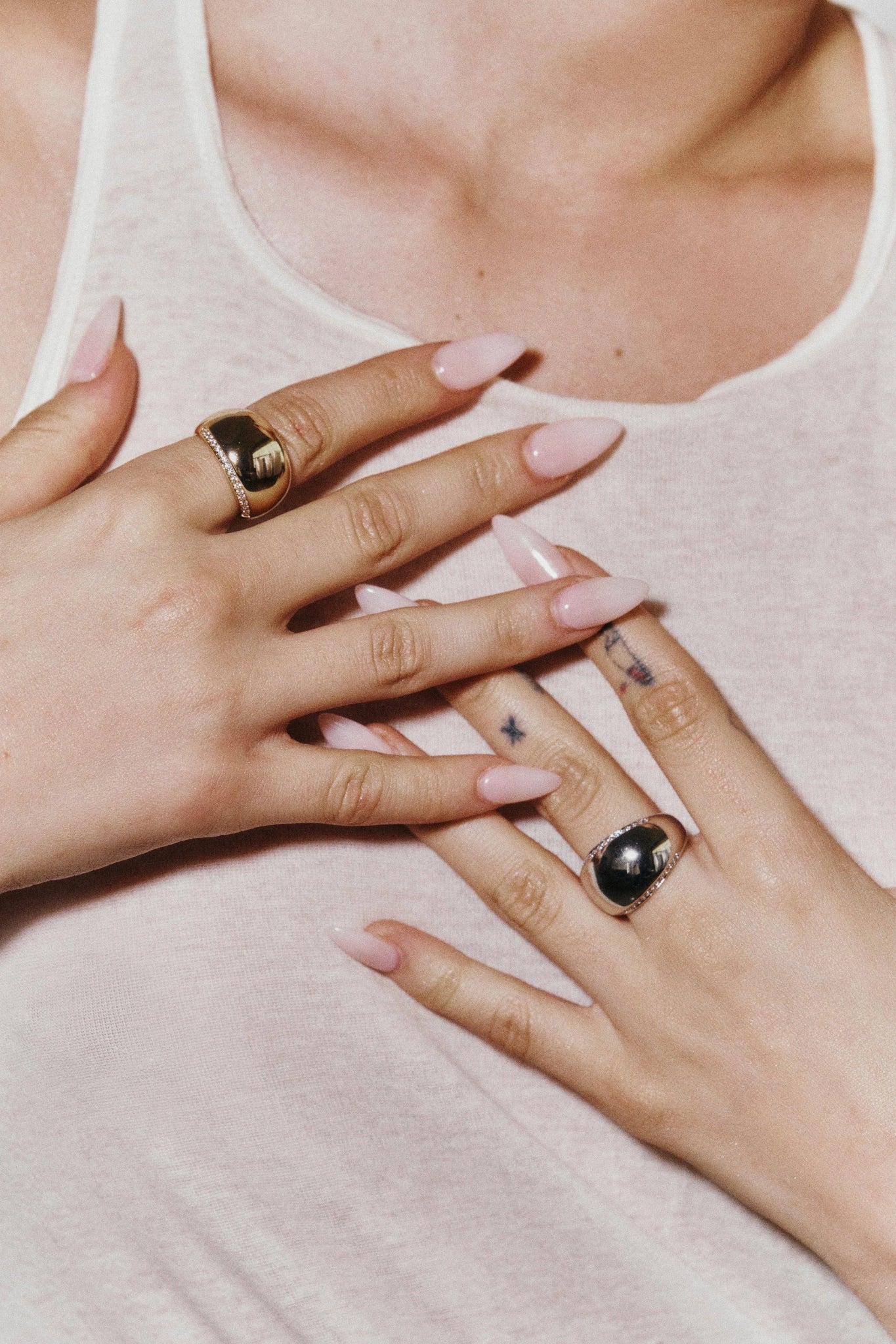 Luxe Pavé Gold Dome Ring on model with both of her hands wearing a gold ring and crossed against her chest