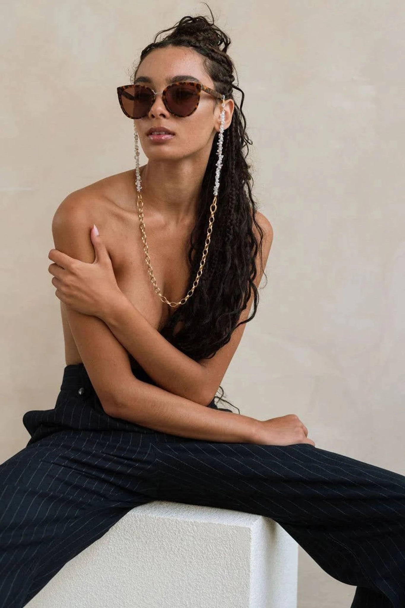 Lyon Golden Pearl Eyeglass Chain on a model. The shells lay ear the face with the chain near the chest.