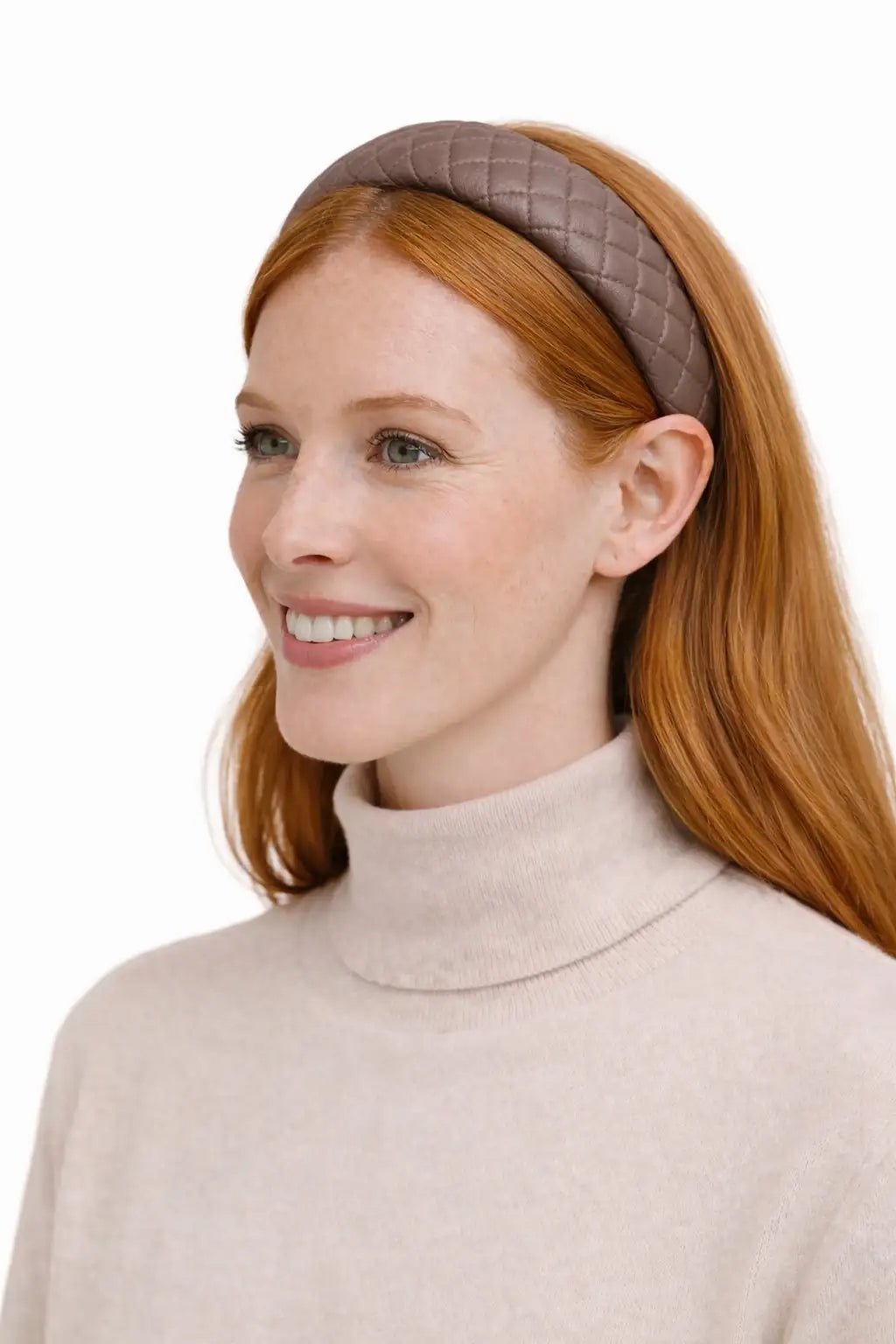 Woman wearing a beige headband and turtleneck sweater on a white background