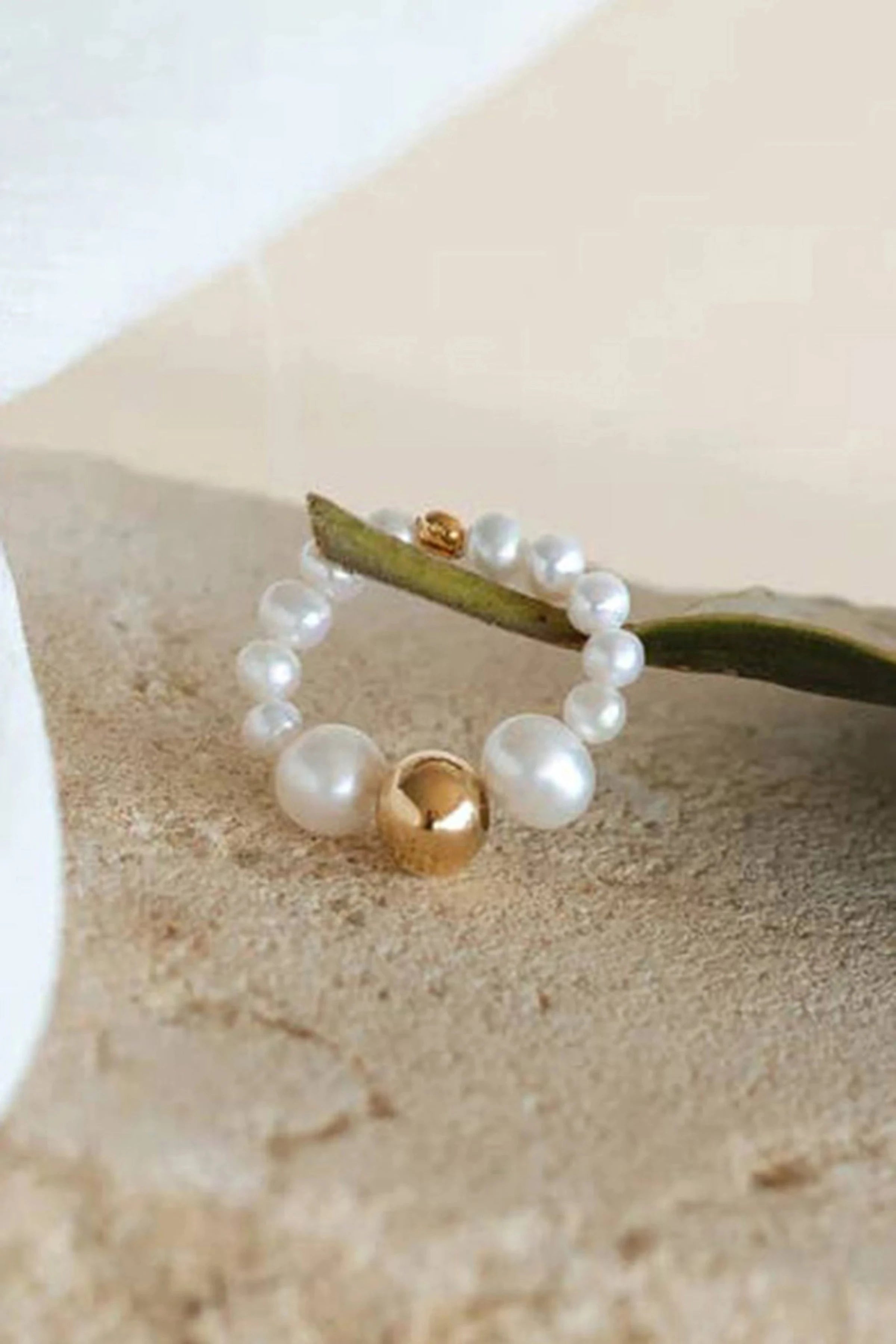 Menton Stretch Golden Pearl Ring on a natural stone background - L'Atelier Global