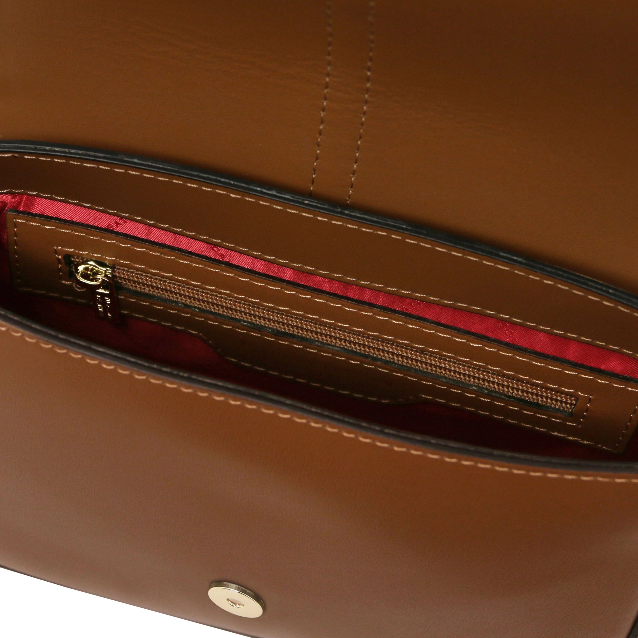 Interior open pocket view Nausica Italian Leather Shoulder Bag in cognac showing red bag lining and magnetic button closure