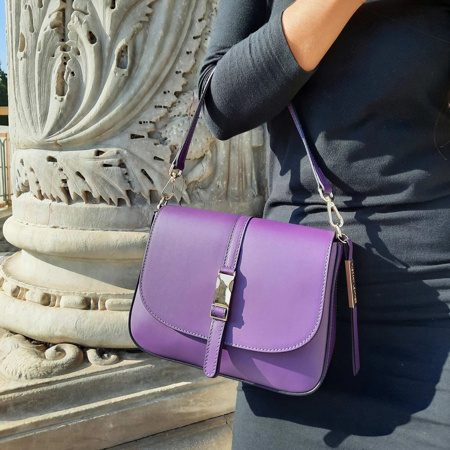 Model holding Nausica Leather Shoulder Bag in Lilac by detachable handle for a more formal wear