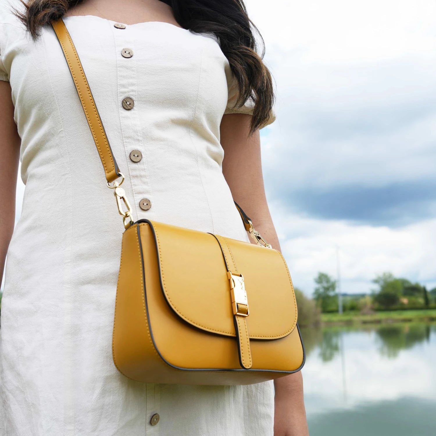 Model wearing Nausica Leather Shoulder Bag in Yellow crossbody by detachable, adjustable crossbody strap for casual wear